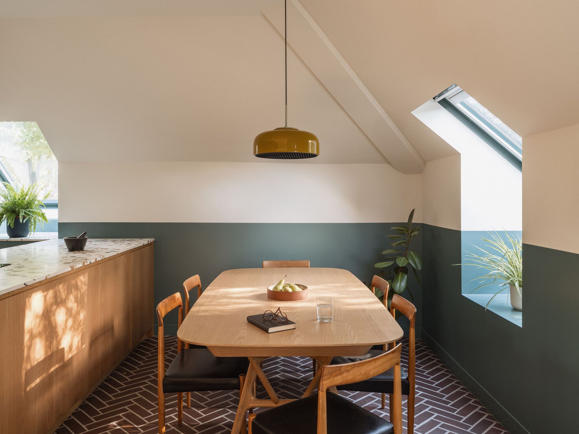 Dining area with vaulted ceiling, skylight and two-tone wall treatment in afternoon sunlight
