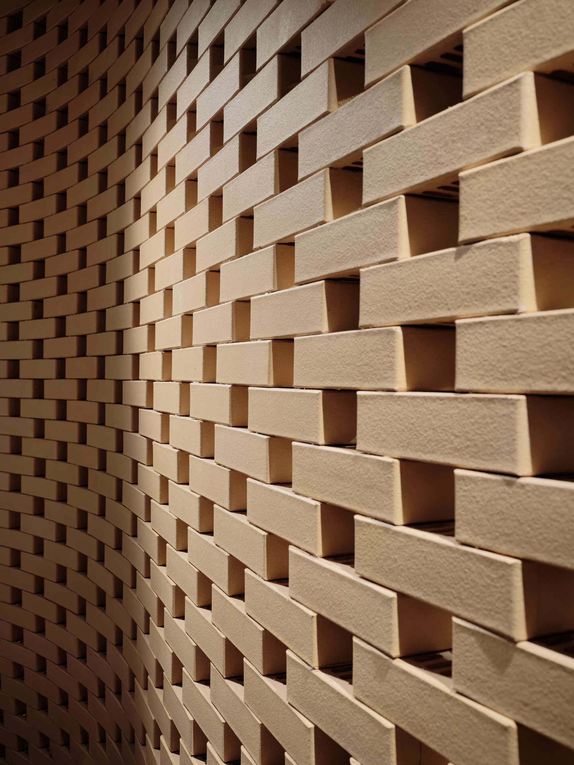 Close-up of staggered timber brick wall creating a basketweave pattern with recessed shadow gaps