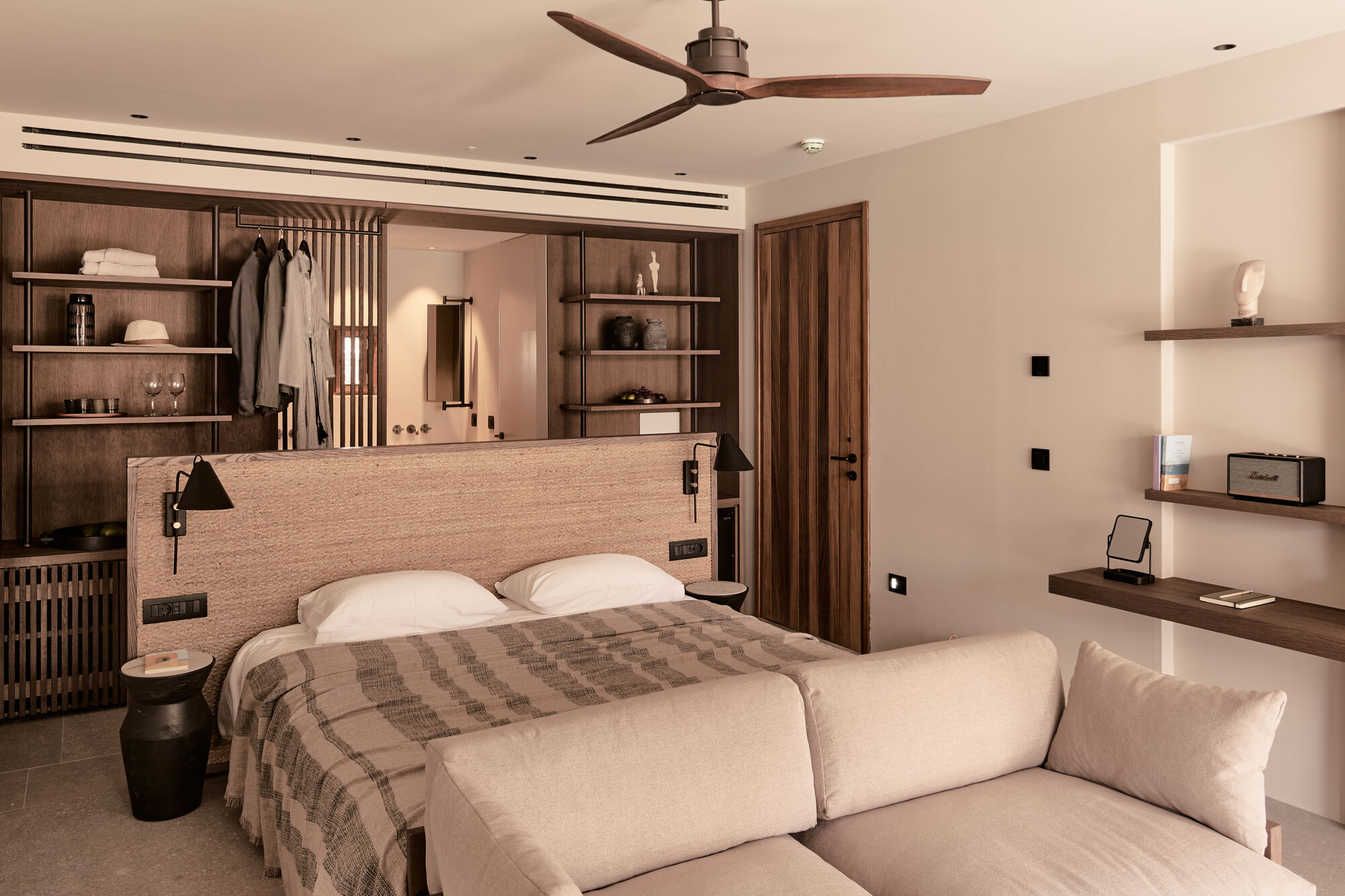 Guest room with timber headboard wall and built-in shelving under a ceiling fan