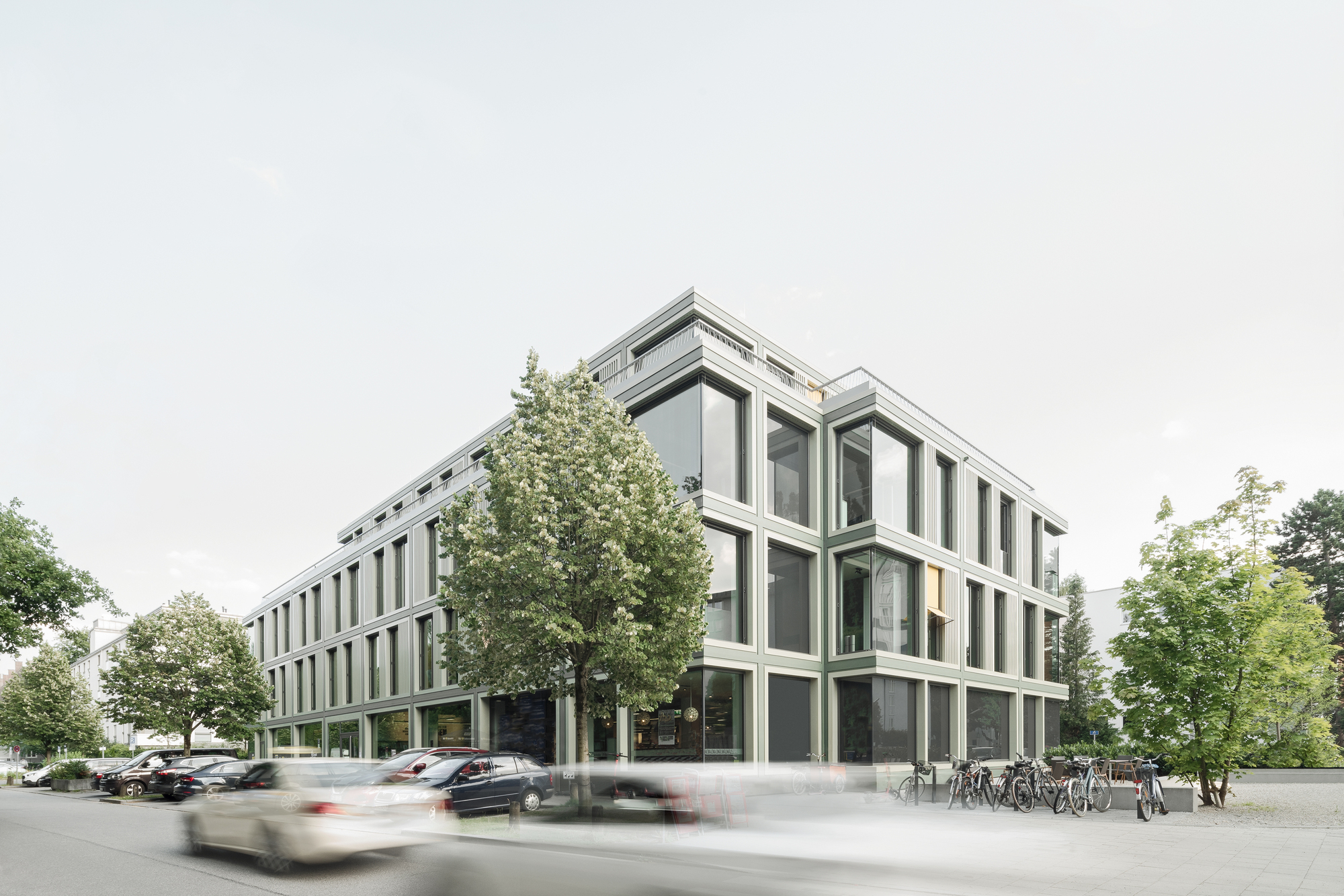 Street corner view of the framed facade with vertical fin mullions and passing traffic