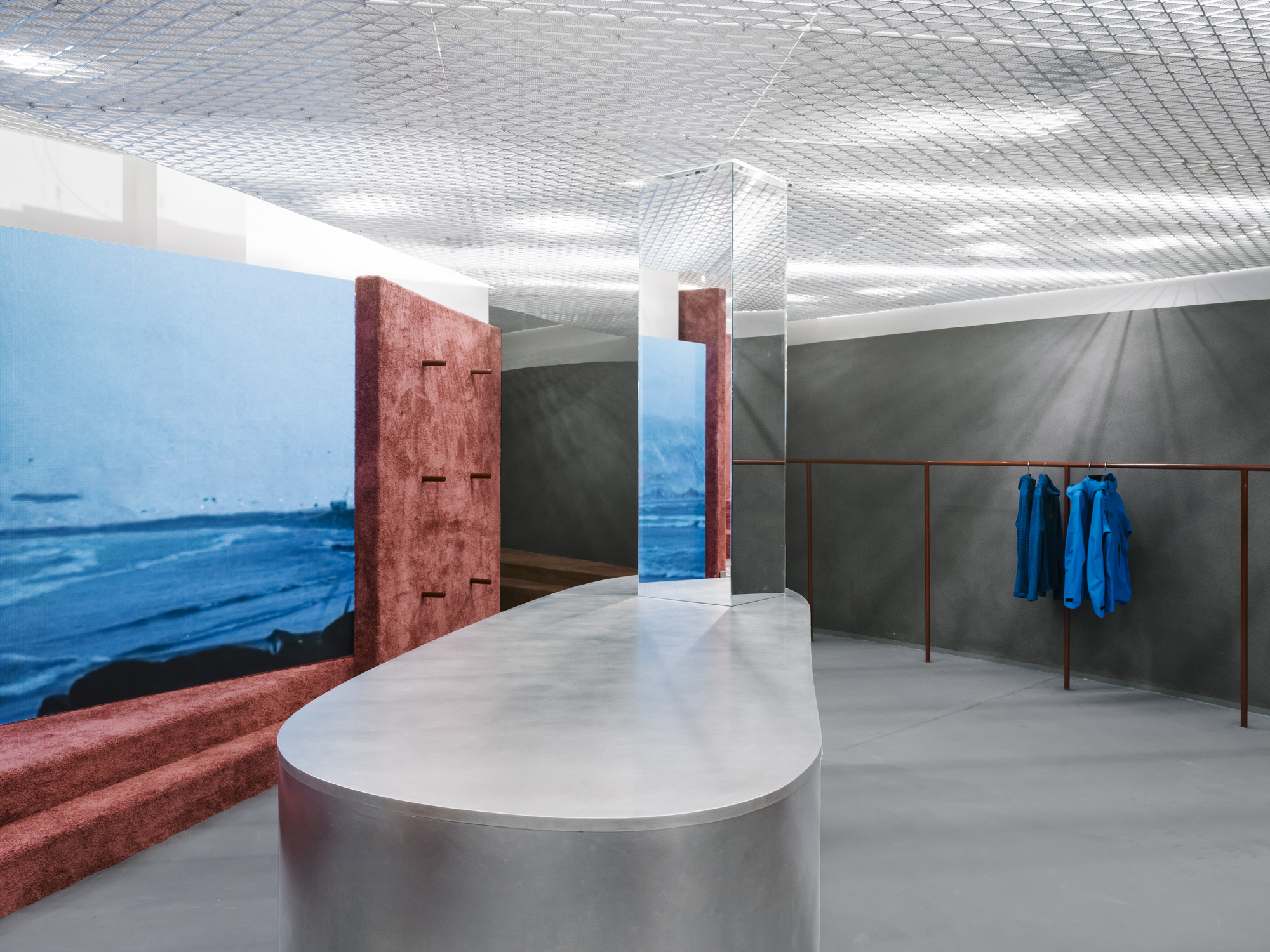 Interior view showing reddish-brown textured columns flanking a doorway with blue garments on a rail
