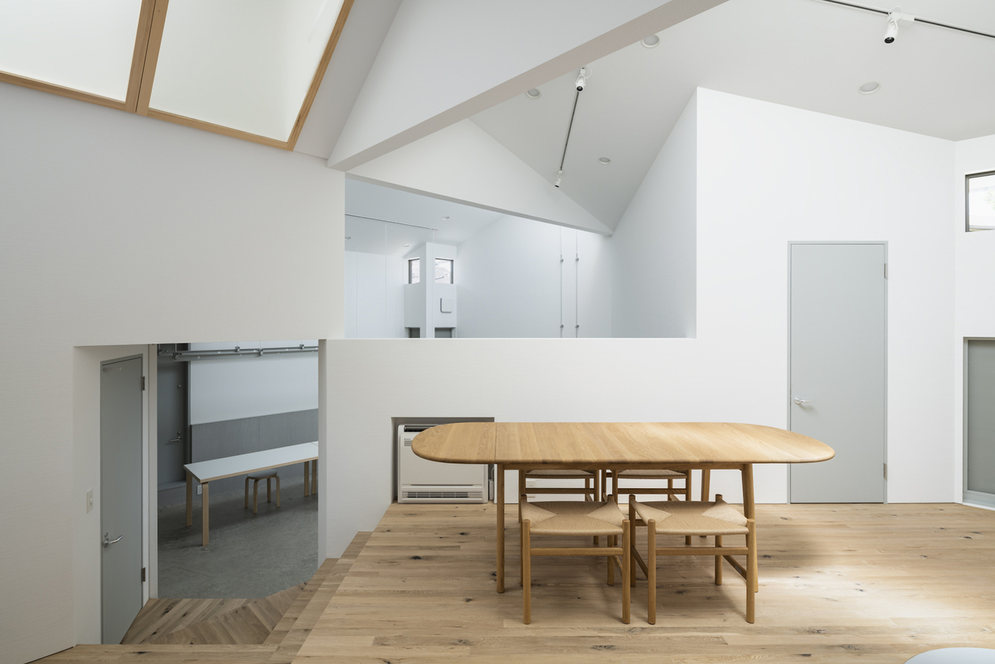 Mezzanine dining area with timber flooring overlooking the lower level concrete floor and sliding door below