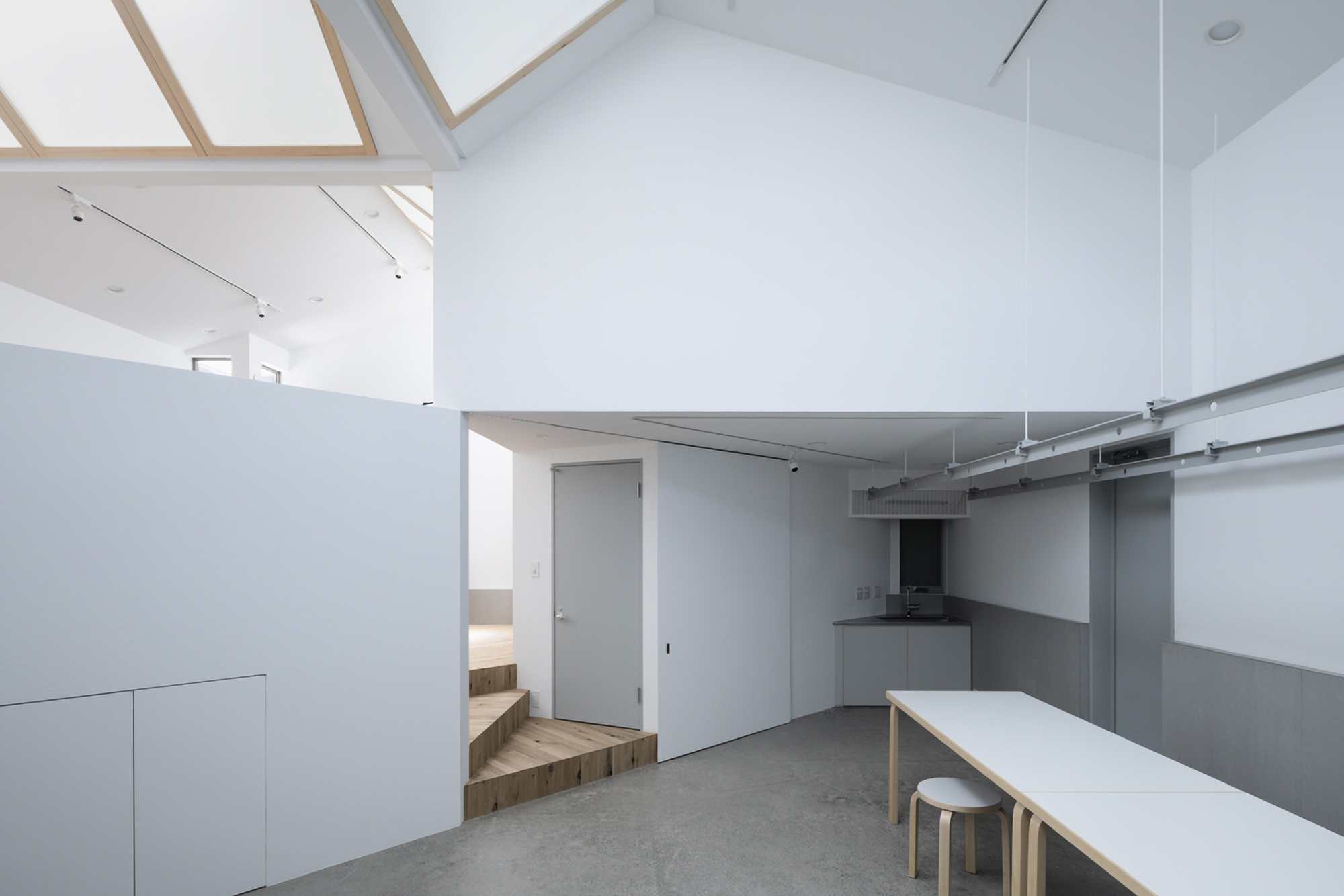 Open kitchen and dining area with exposed ductwork and timber-framed skylights above