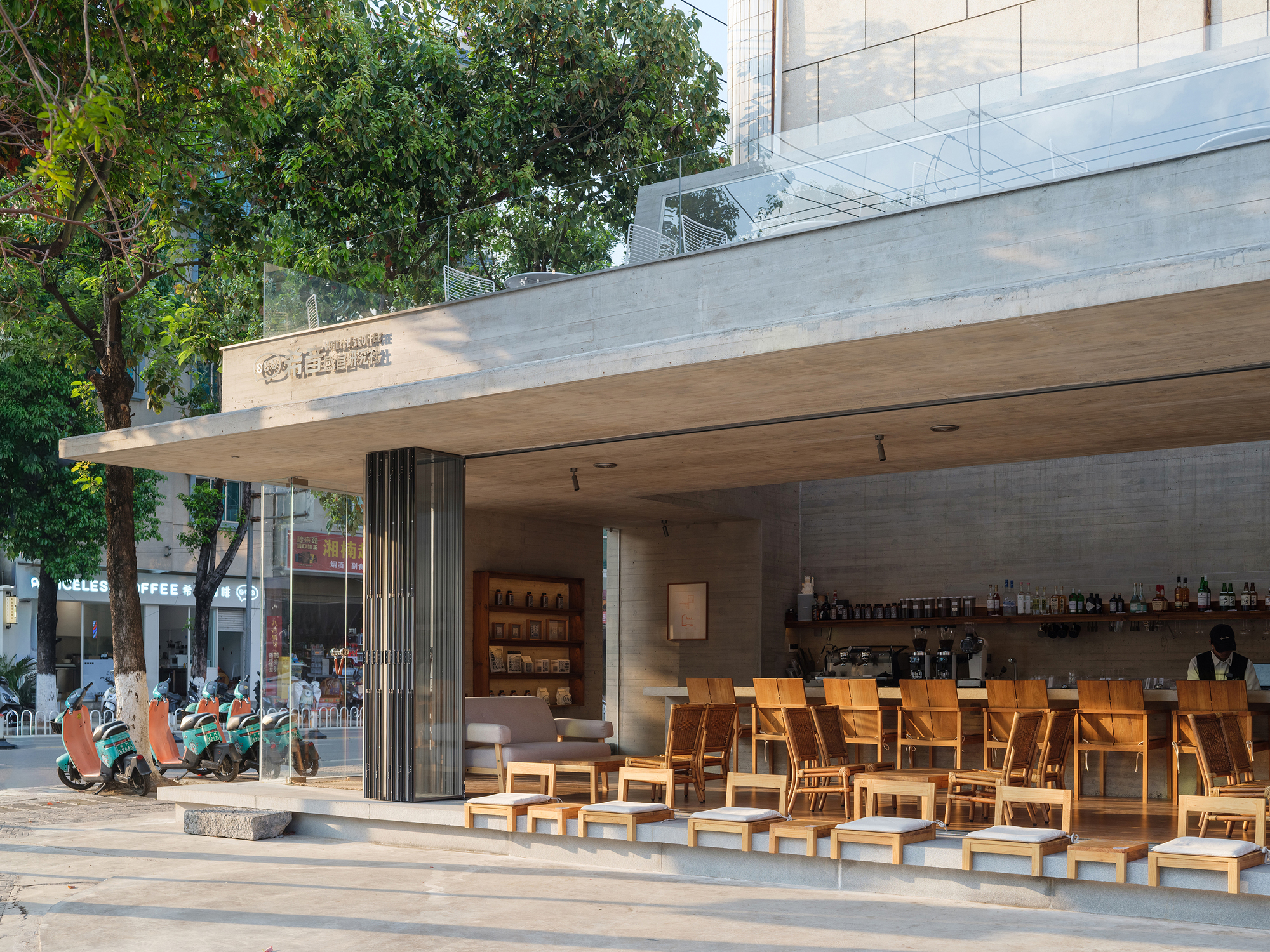 Covered outdoor seating area with timber furniture and concrete canopy with wood soffit