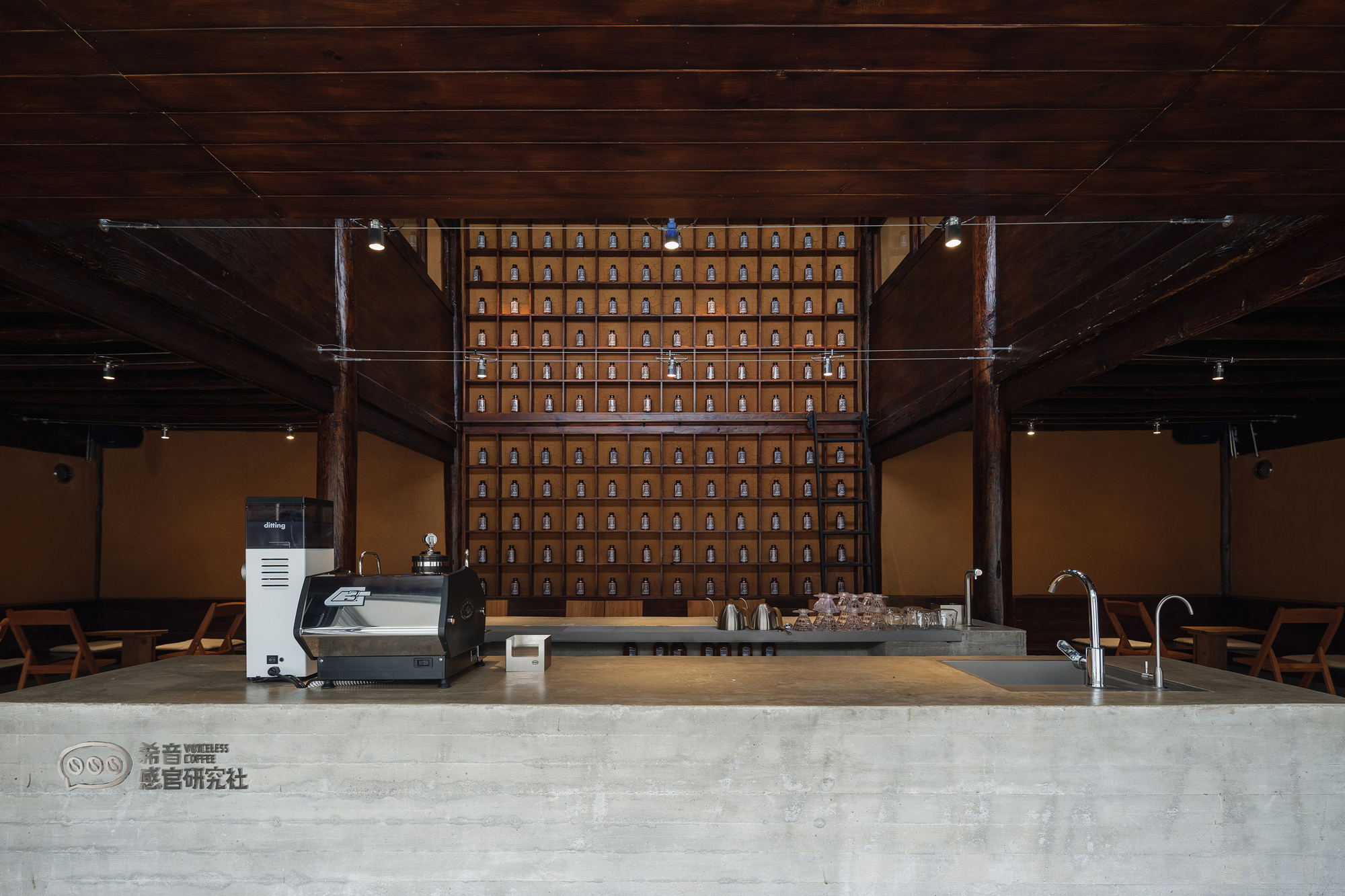 Service counter with grid of wooden storage drawers mounted on rear wall under dark timber ceiling