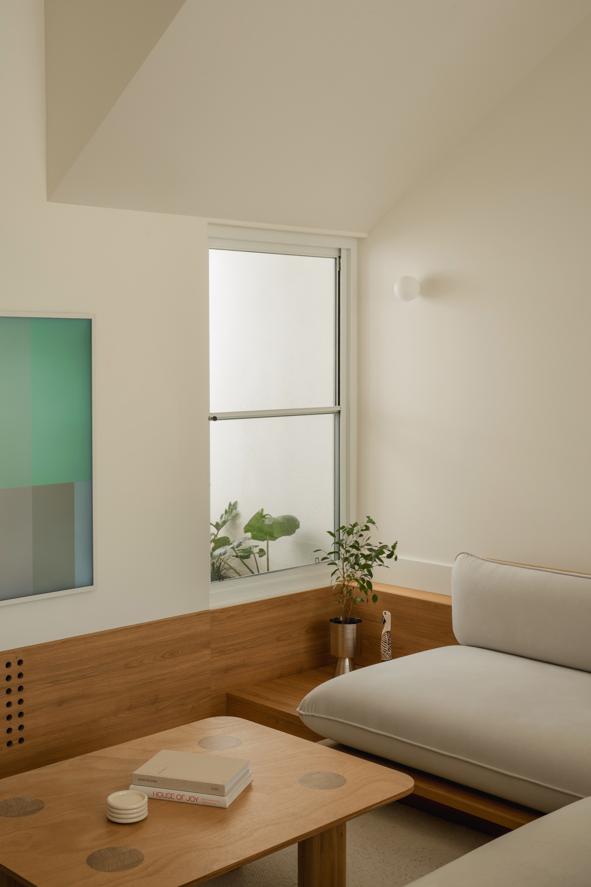 Timber window ledge with potted plants beside built-in seating in daylight
