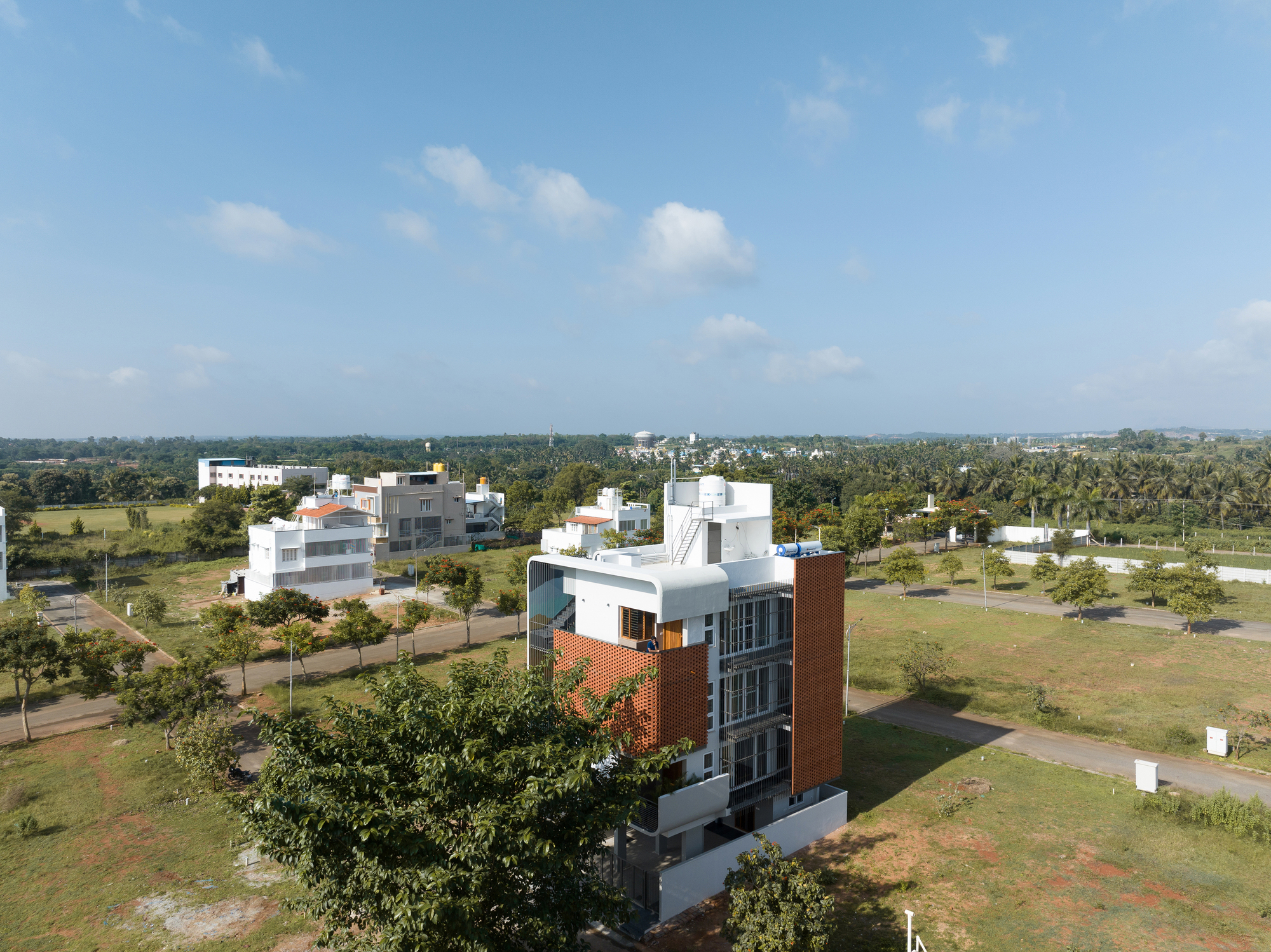 Aerial view of the tower set within a landscaped residential development with scattered trees and open fields