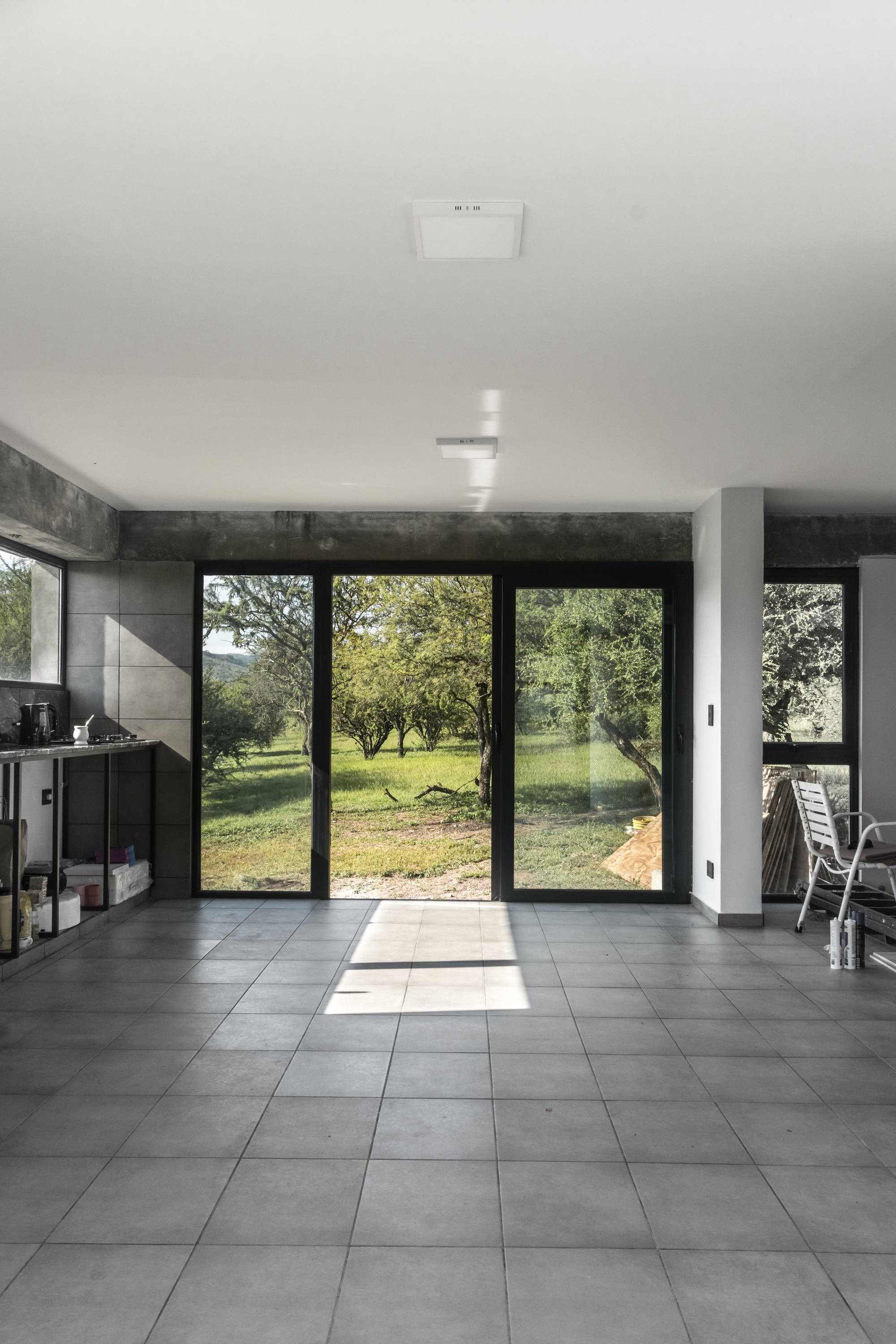 Open living space with gray tile floor and sliding glass doors opening to garden