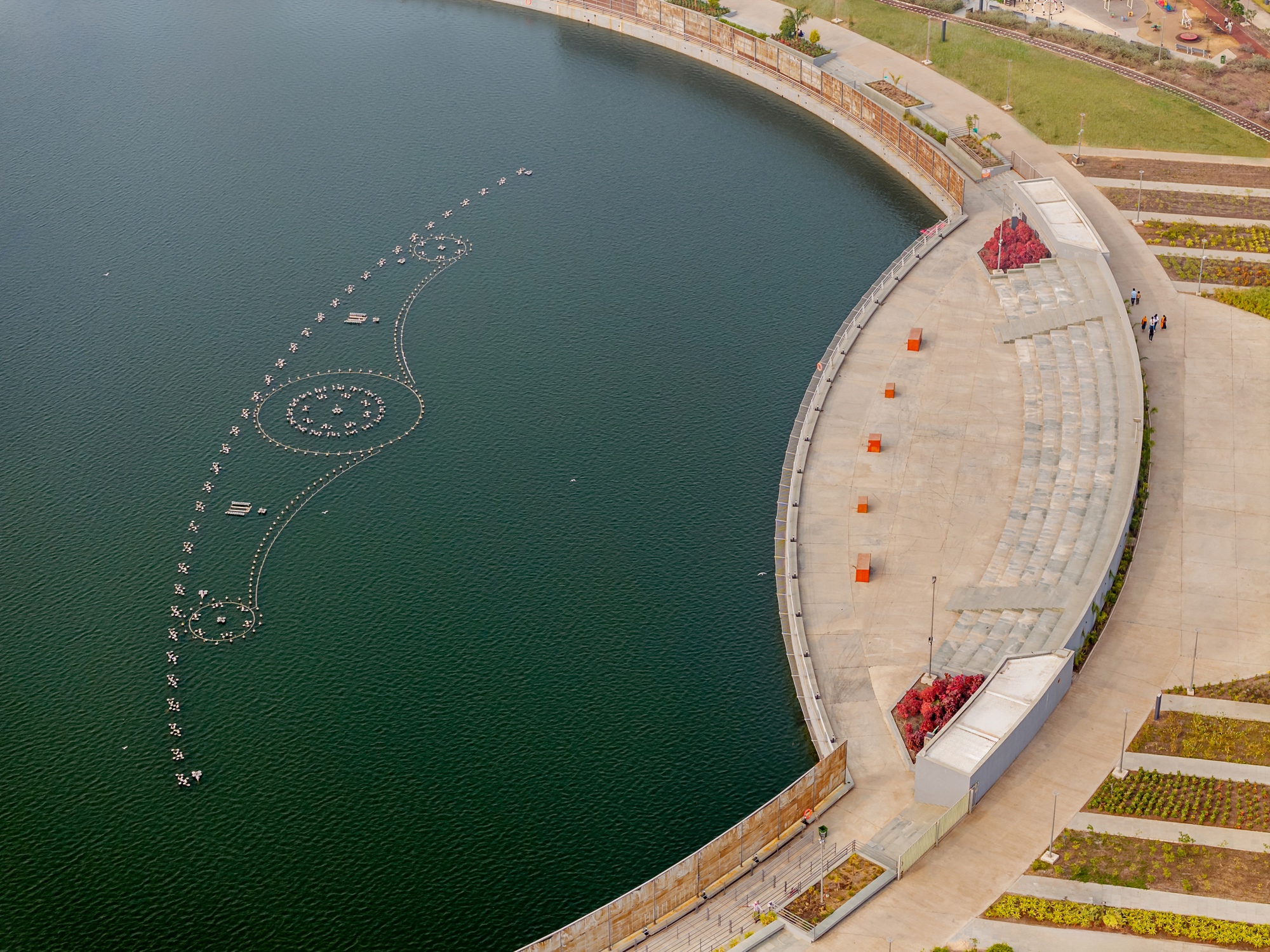 Overhead view of the curved amphitheater seating adjacent to the water with floating light installation
