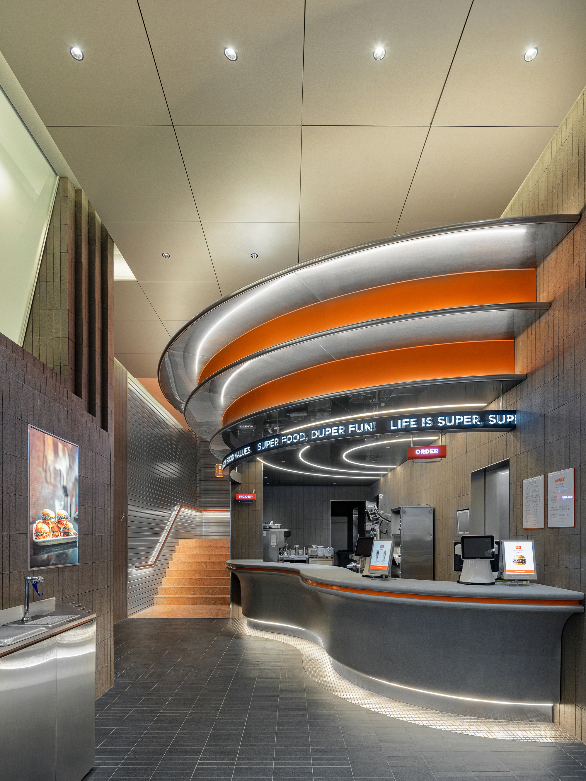 Interior counter with curved grey and orange canopy beneath acoustic ceiling panels