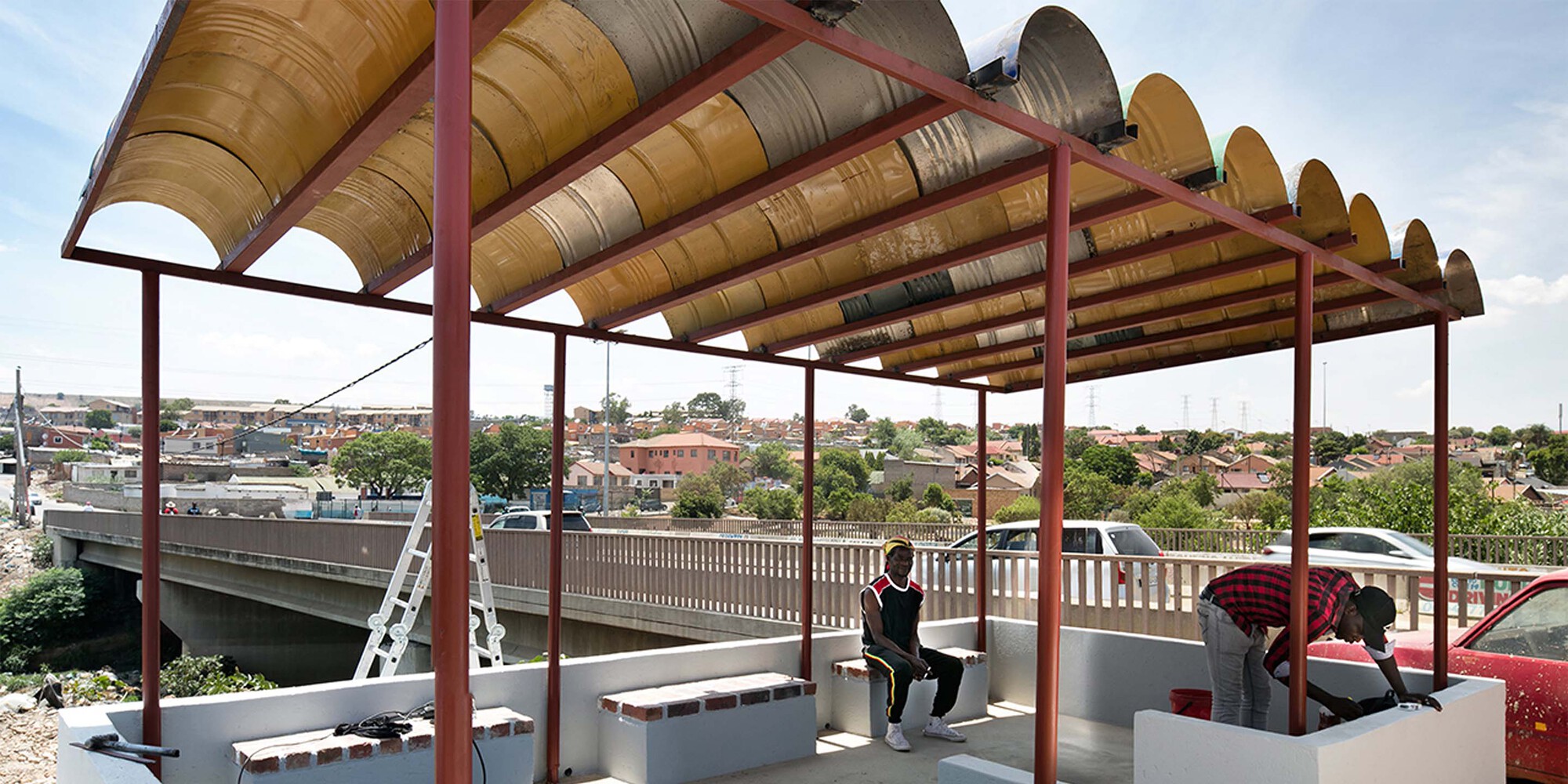 Close-up of the arched metal roof structure with brown painted barrel vaults over seating areas