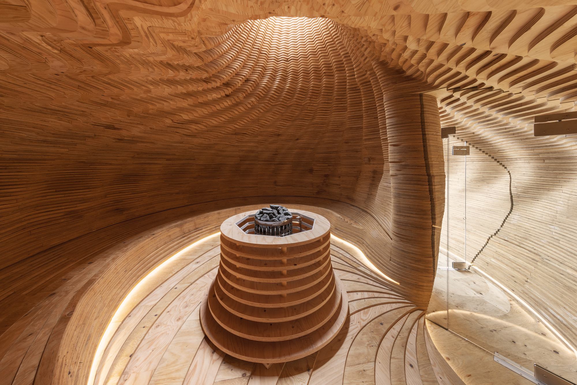 Interior view of the laminated wood sauna chamber with central heater and radial benches