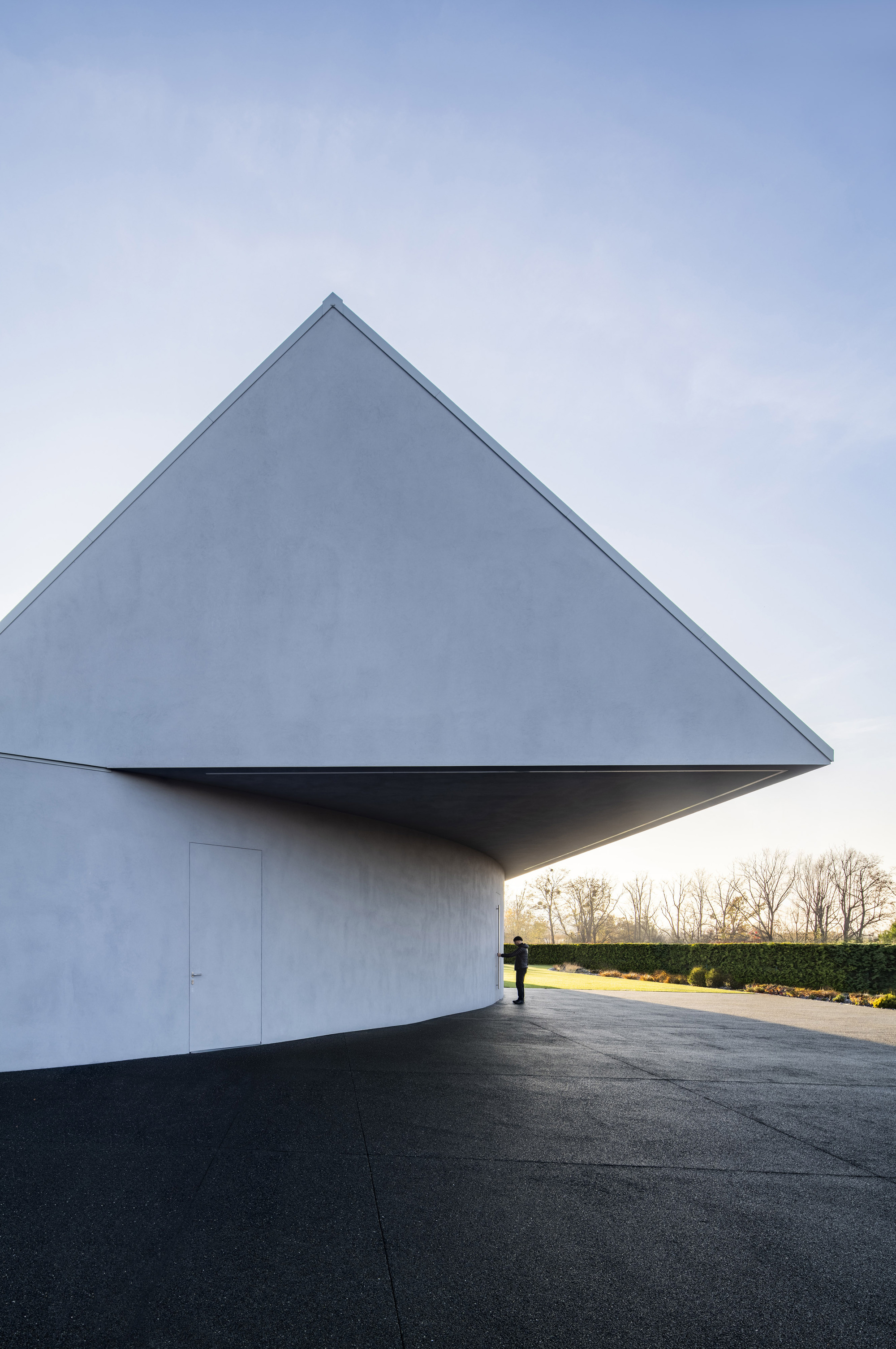 Triangular gable end with recessed entry and cantilevered overhang at dusk