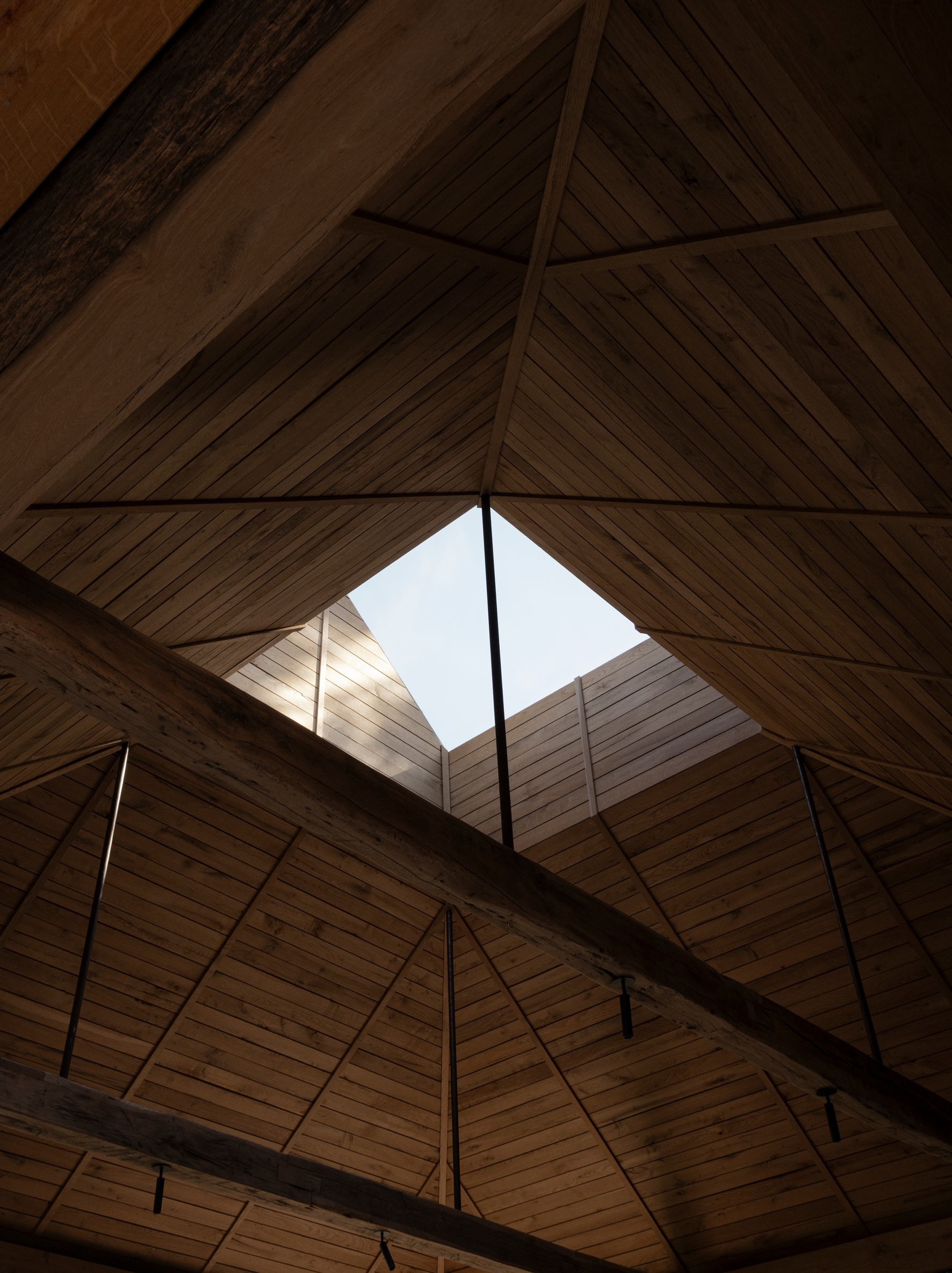 Interior view of the pitched timber ceiling with exposed beams and central skylight above