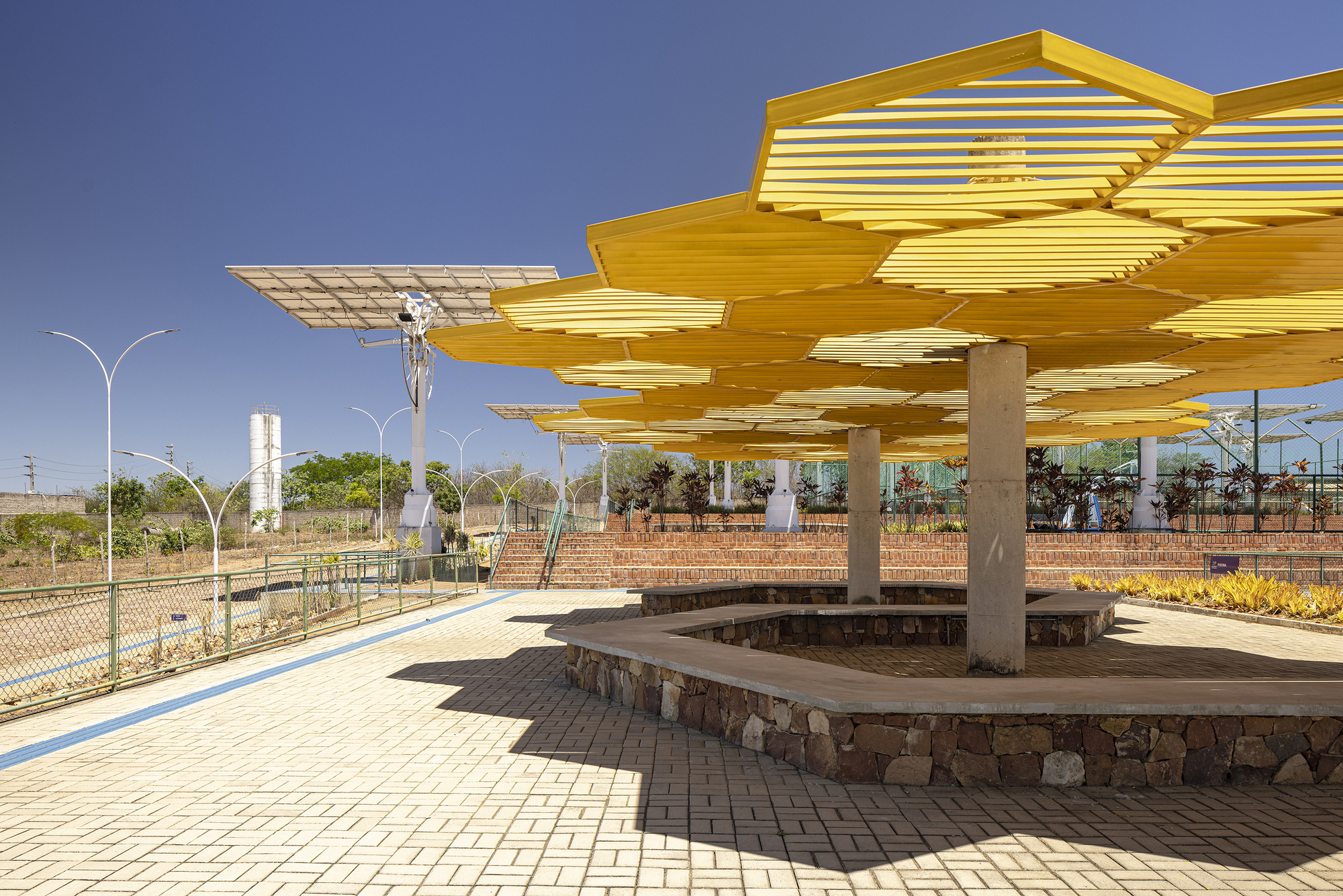Yellow canopy detail supported by cylindrical concrete columns with water tower visible in background