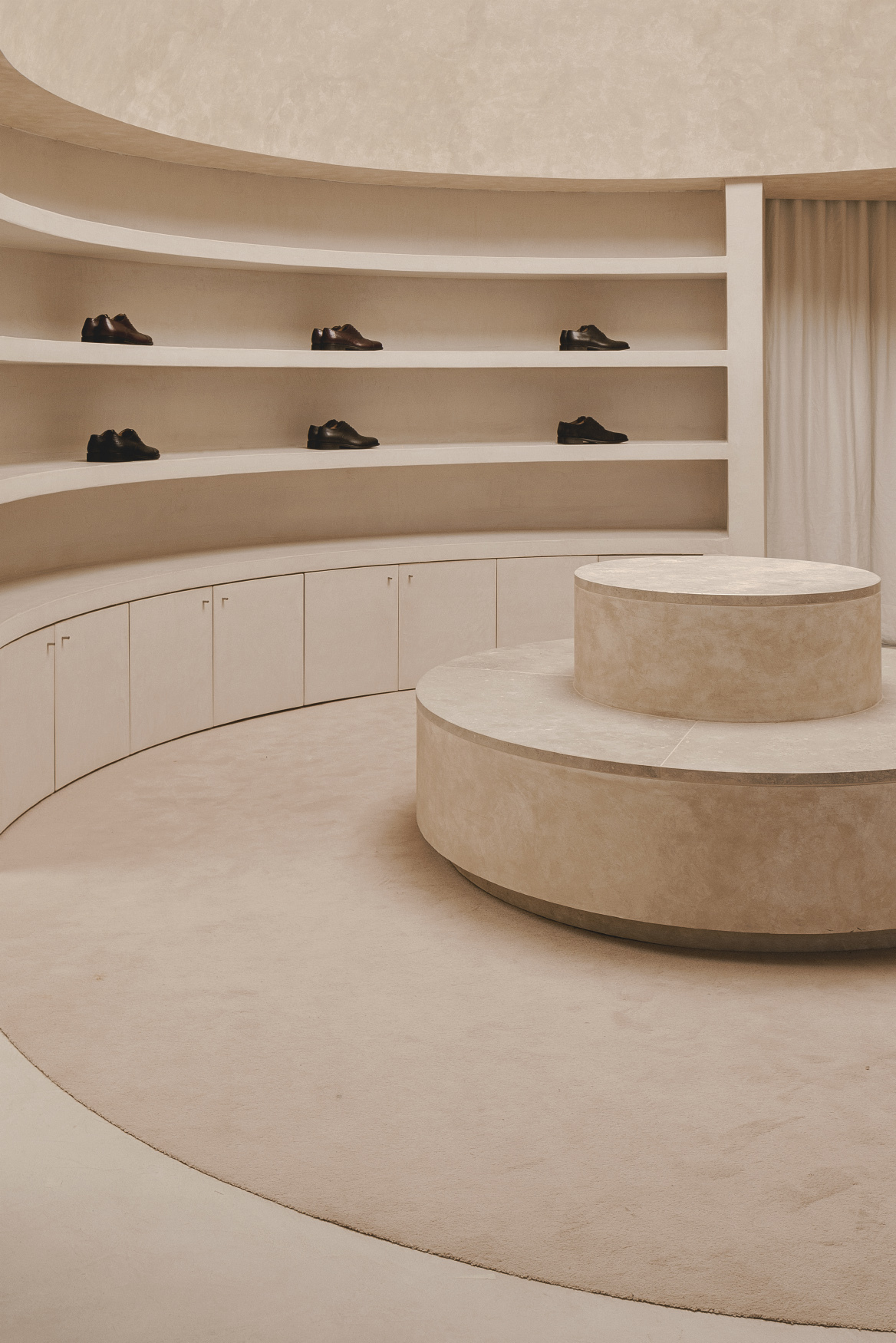 Close-up of the limestone-clad display podium with curved shelving along the perimeter wall
