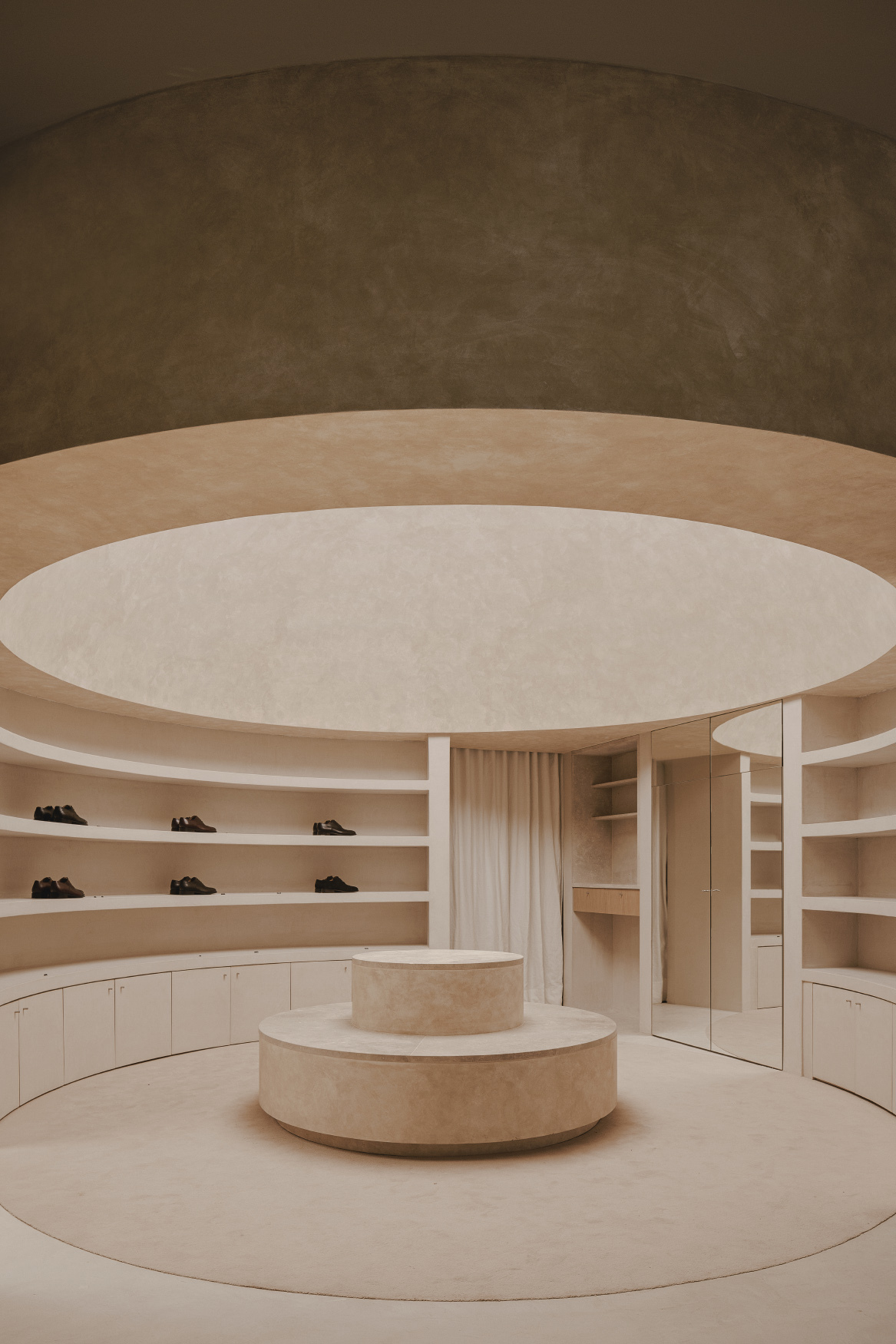 View of the cylindrical stone display podium beneath concentric ceiling rings with integrated lighting