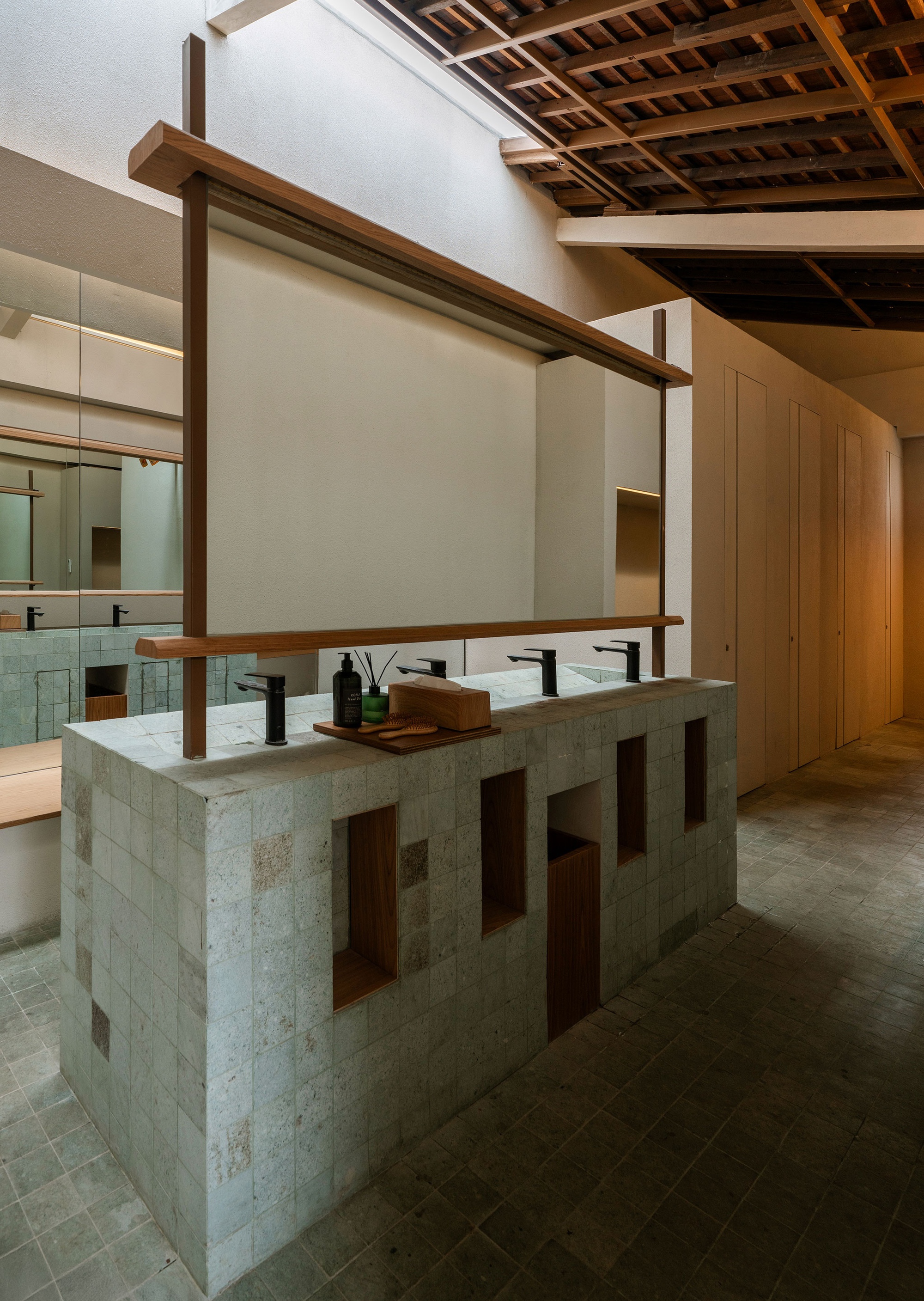 Concrete vanity counter with timber frame shelving above under an exposed wood joist ceiling