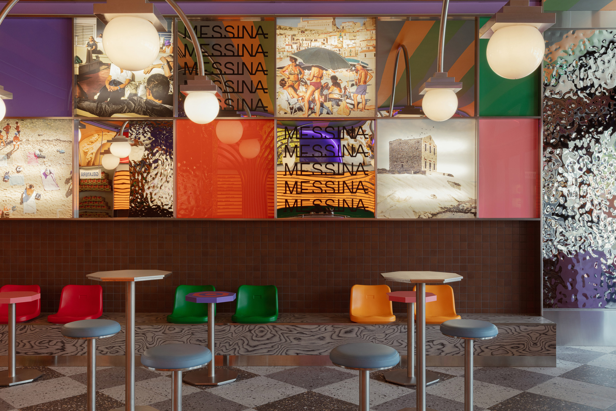 Seating area with colorful molded plastic stools and mosaic wall collage above brown tiled counter