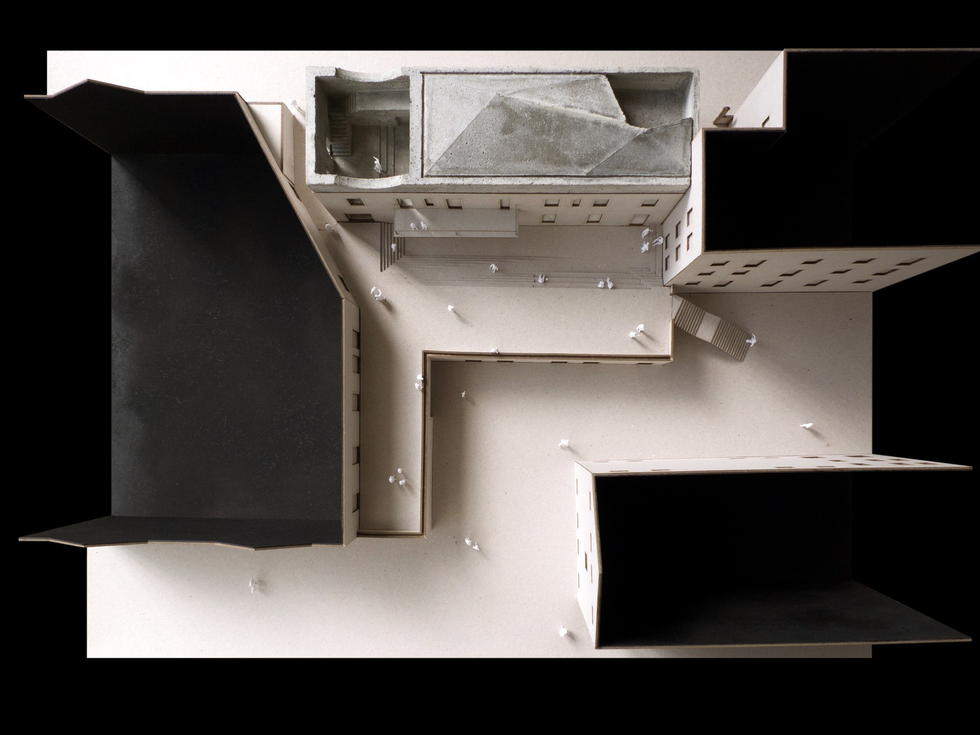 Top-down view of a physical model showing an interior courtyard with small figures and surrounding rooms