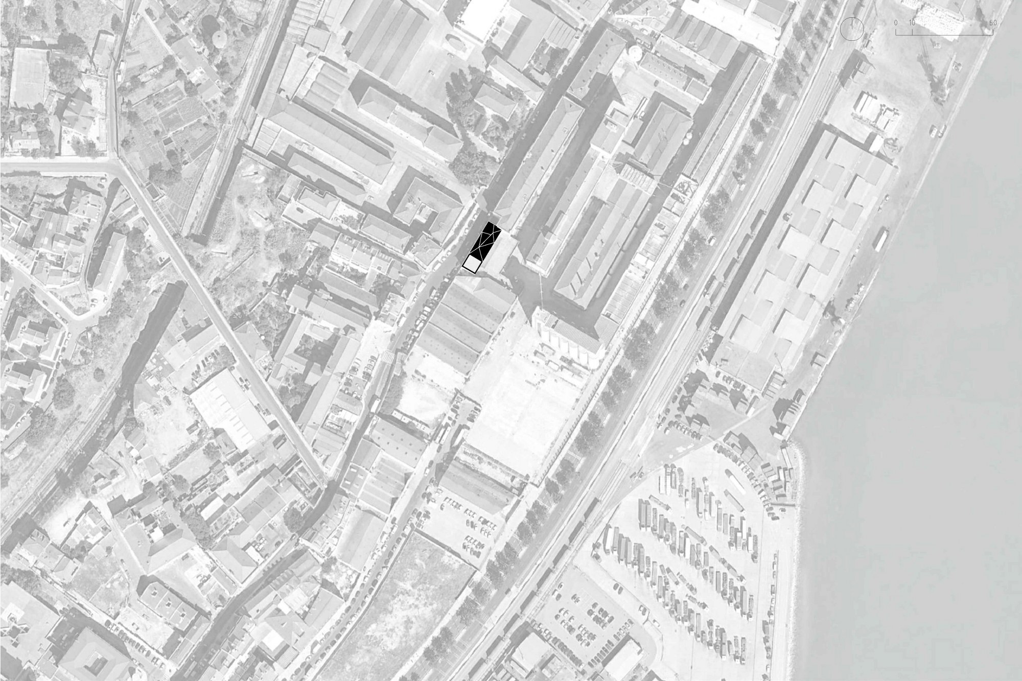 Site plan drawing showing a single building footprint highlighted in black within a dense urban block