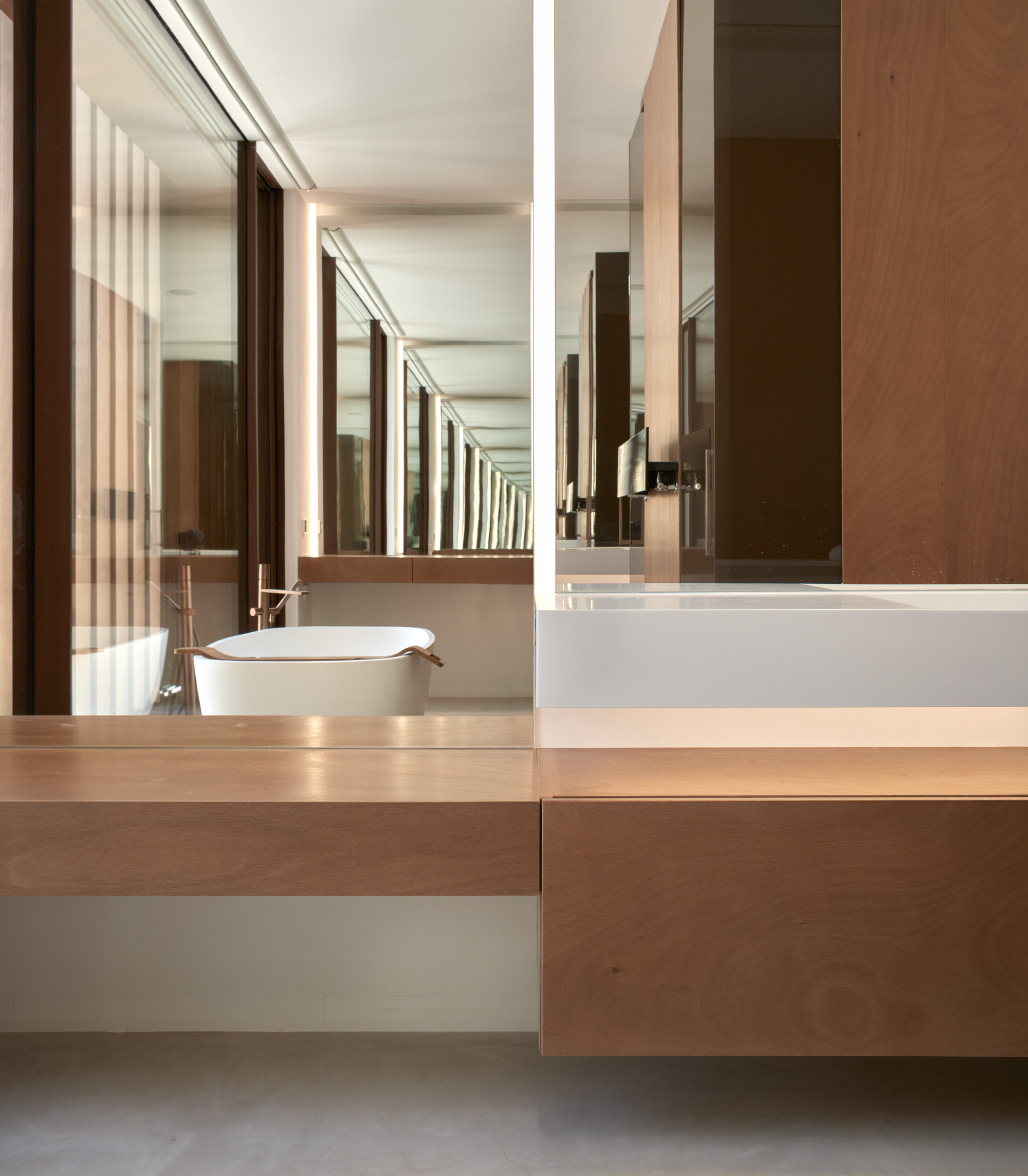 Floating timber vanity with vessel sink beneath mirrored wall reflecting wood slat screen