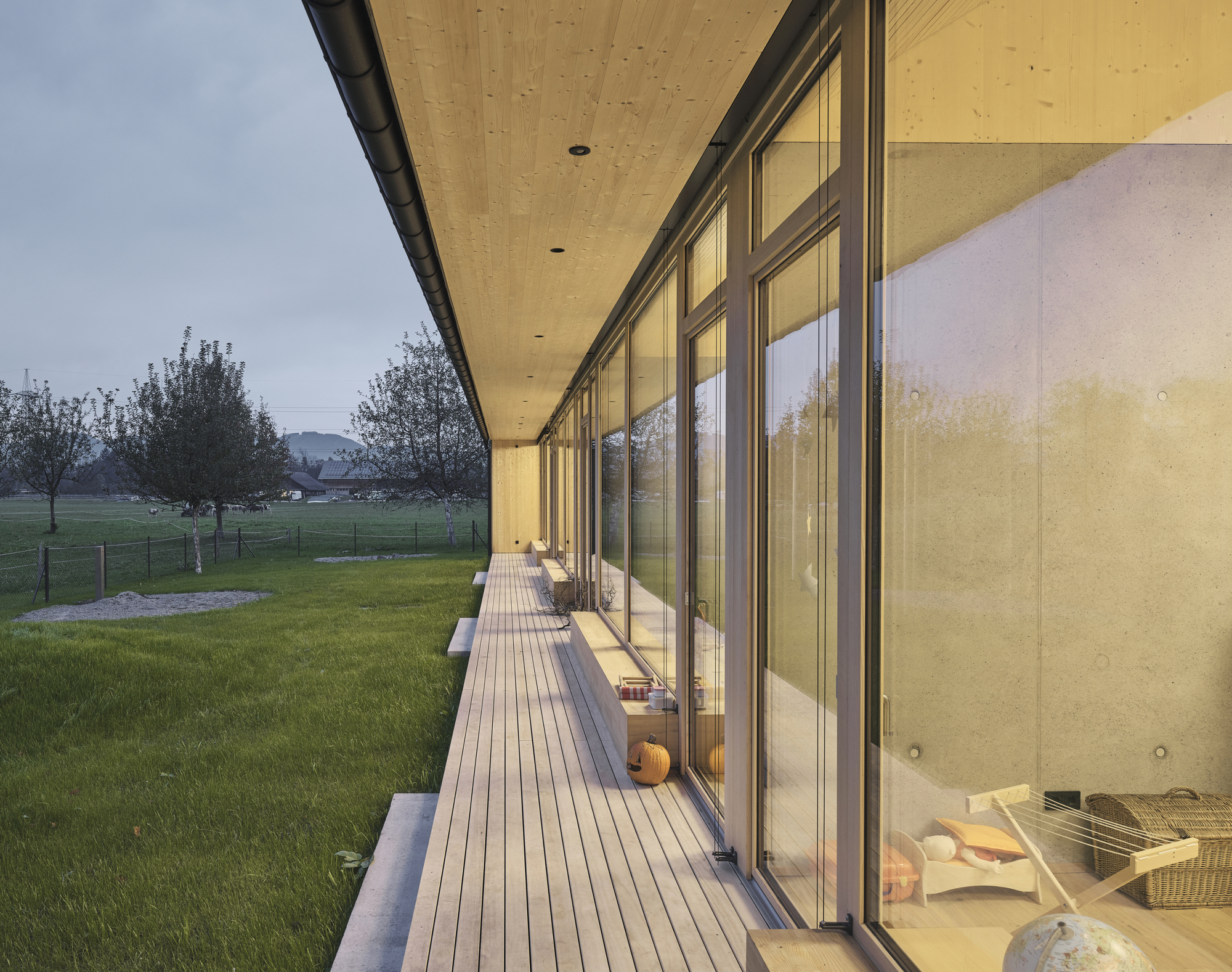 Exterior terrace with wood decking and sliding glass doors at dusk