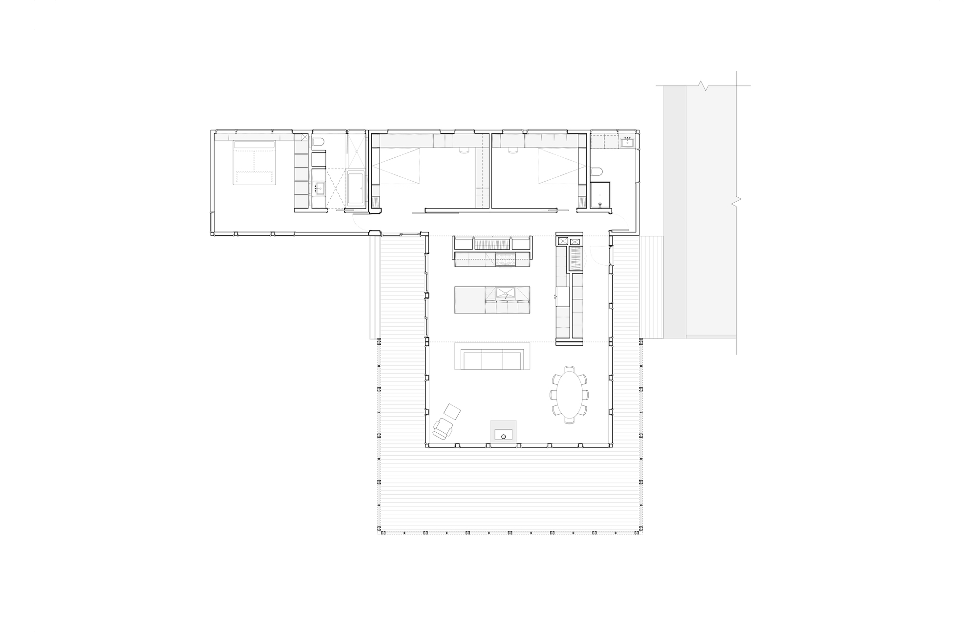 Floor plan showing L-shaped layout with open living area and bedroom wing flanked by wraparound deck