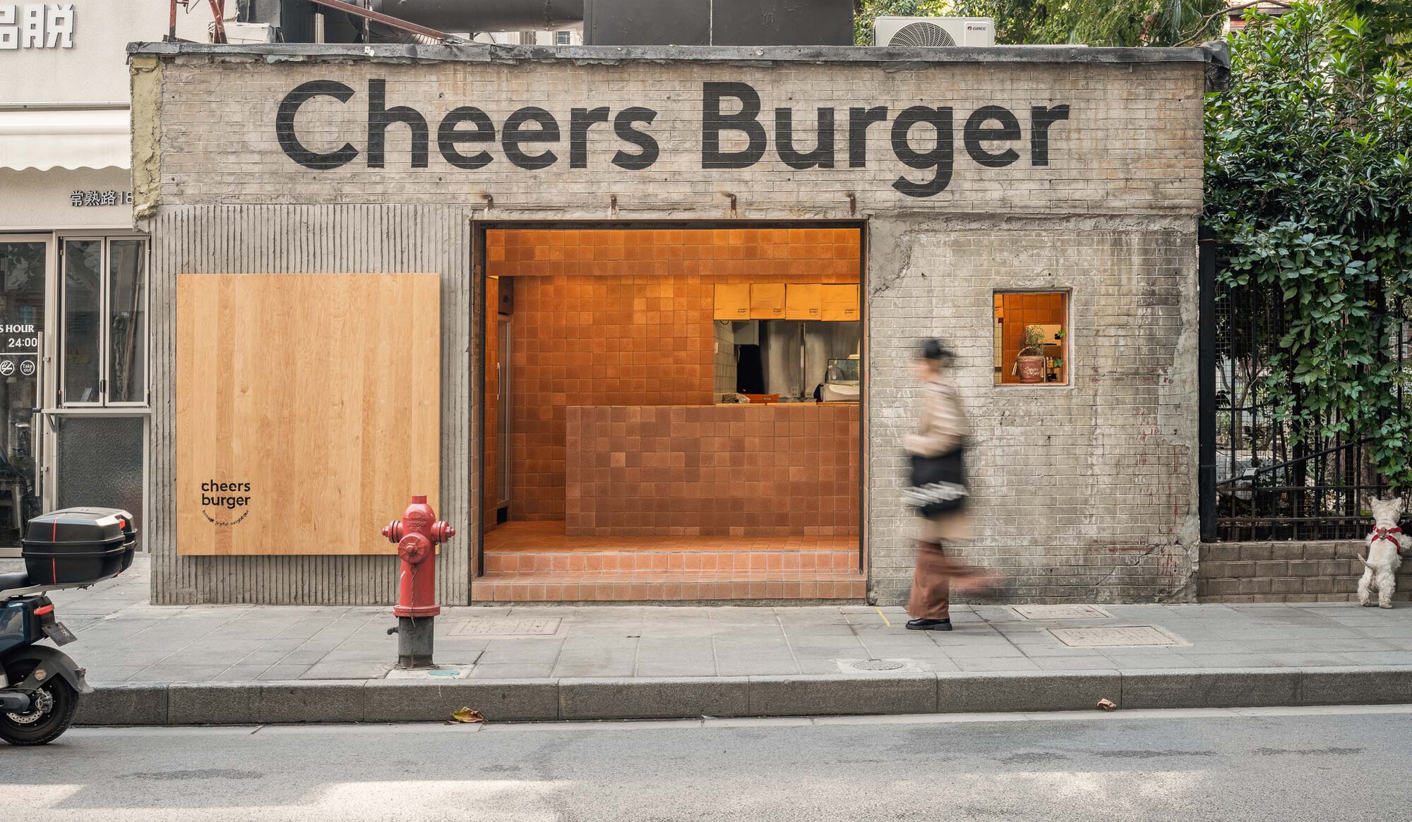 Shopfront with terracotta tile interior visible through the opening and pedestrians walking by