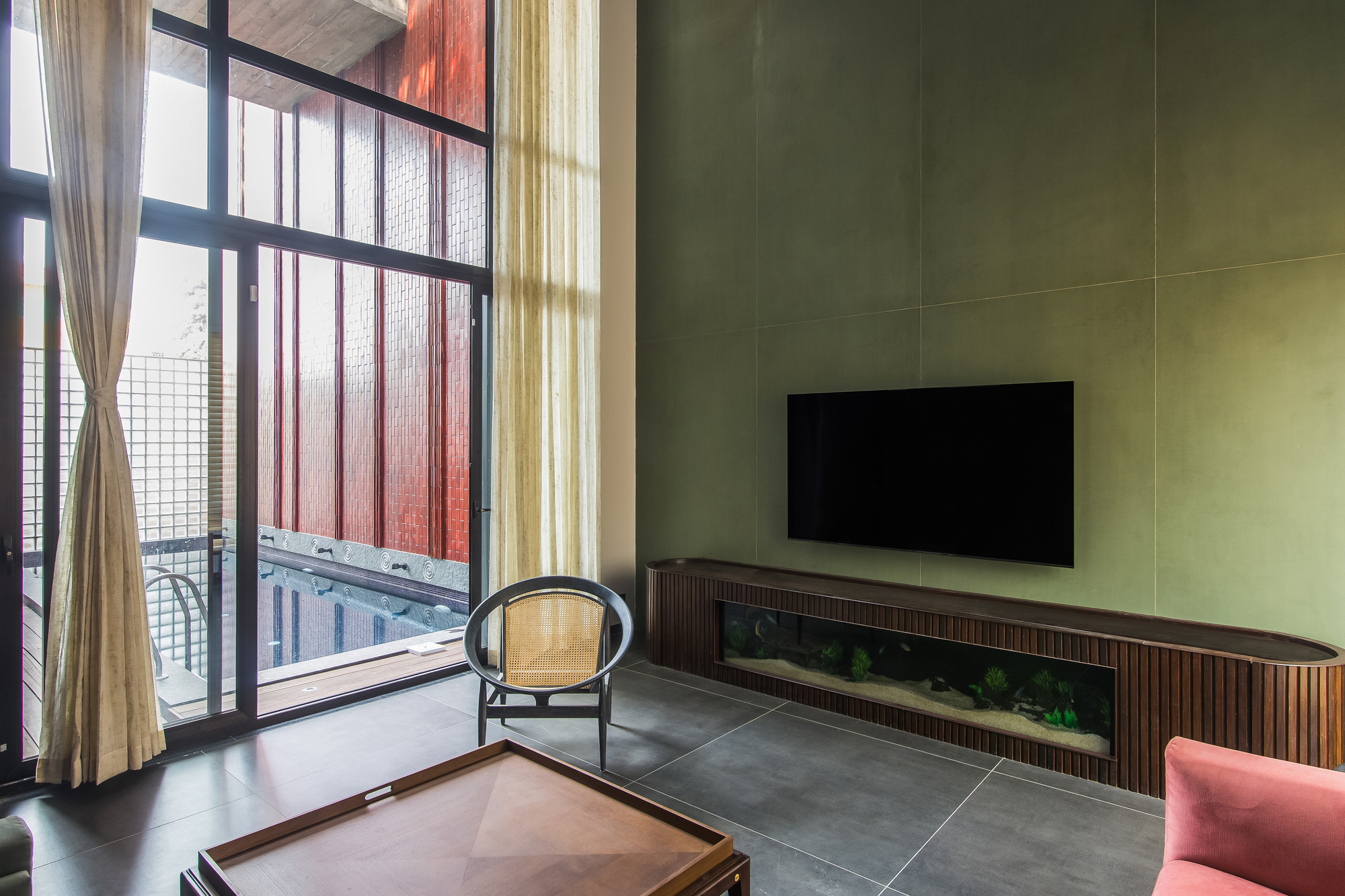 Living room with yellow paneled wall and glass-block balcony doors filtered by pink and beige curtains