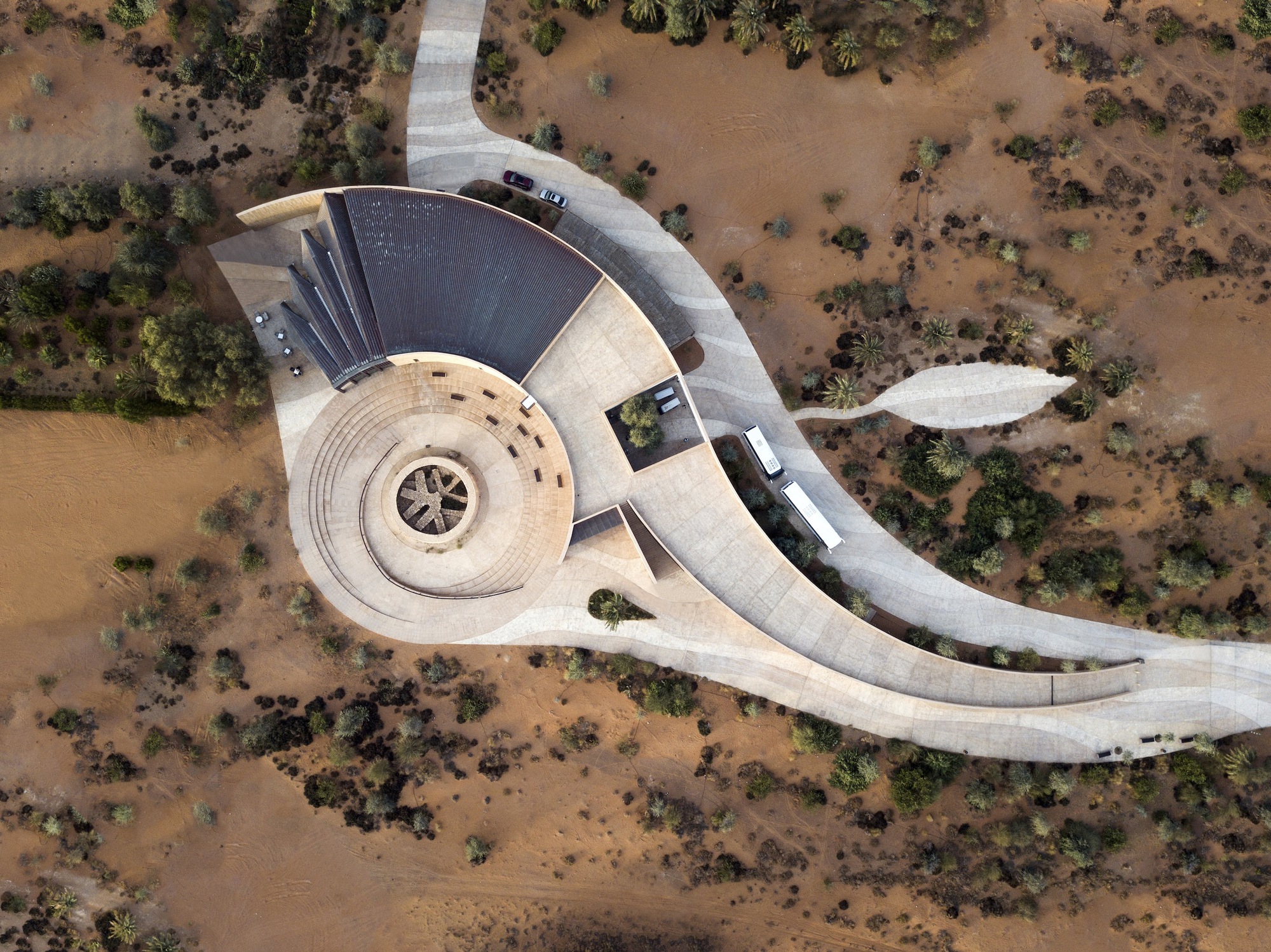 Aerial view of the spiral amphitheater and curving concrete access road through arid scrubland