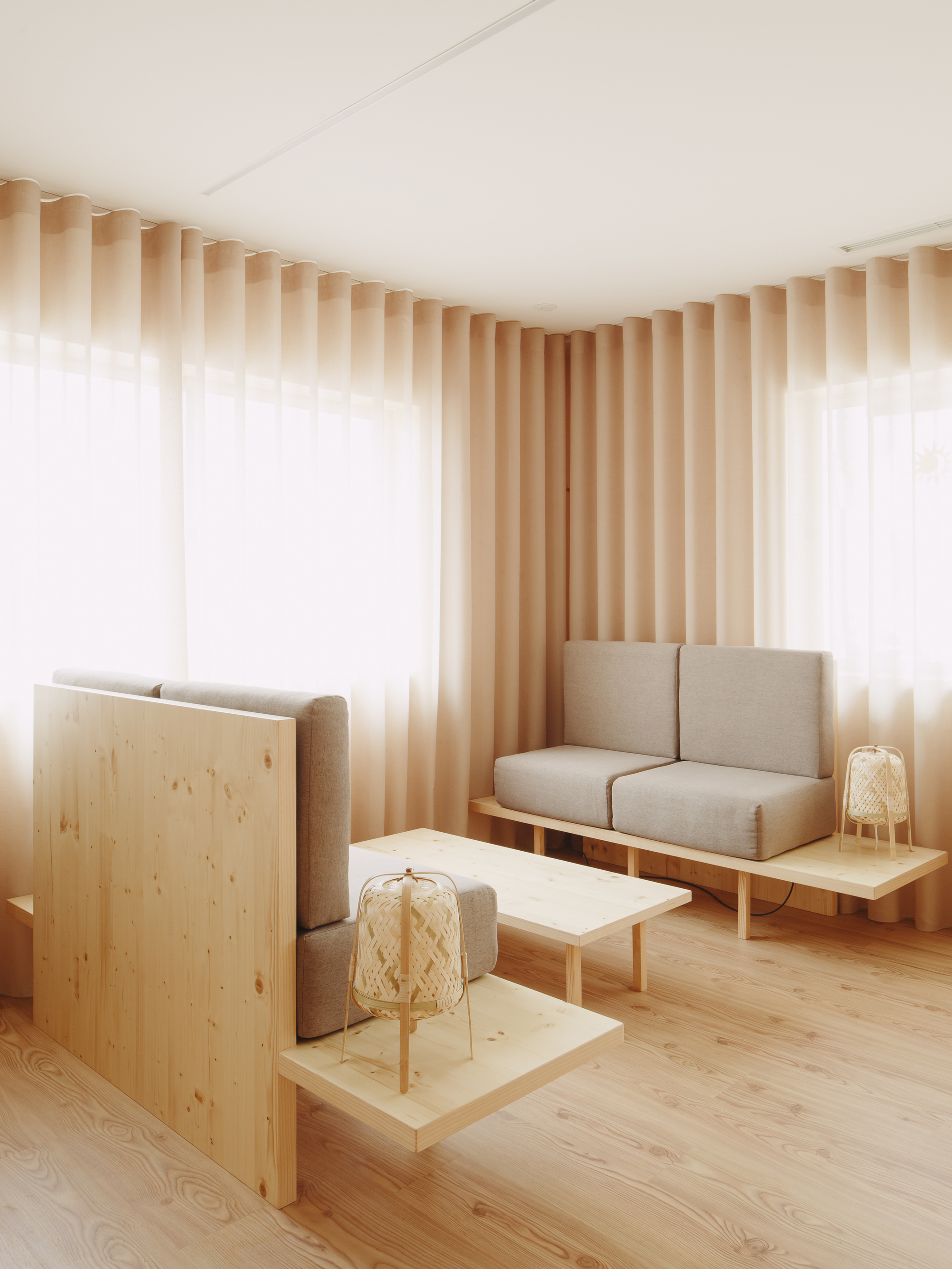 Plywood partition dividing the lounge area with wicker lanterns on low timber platforms
