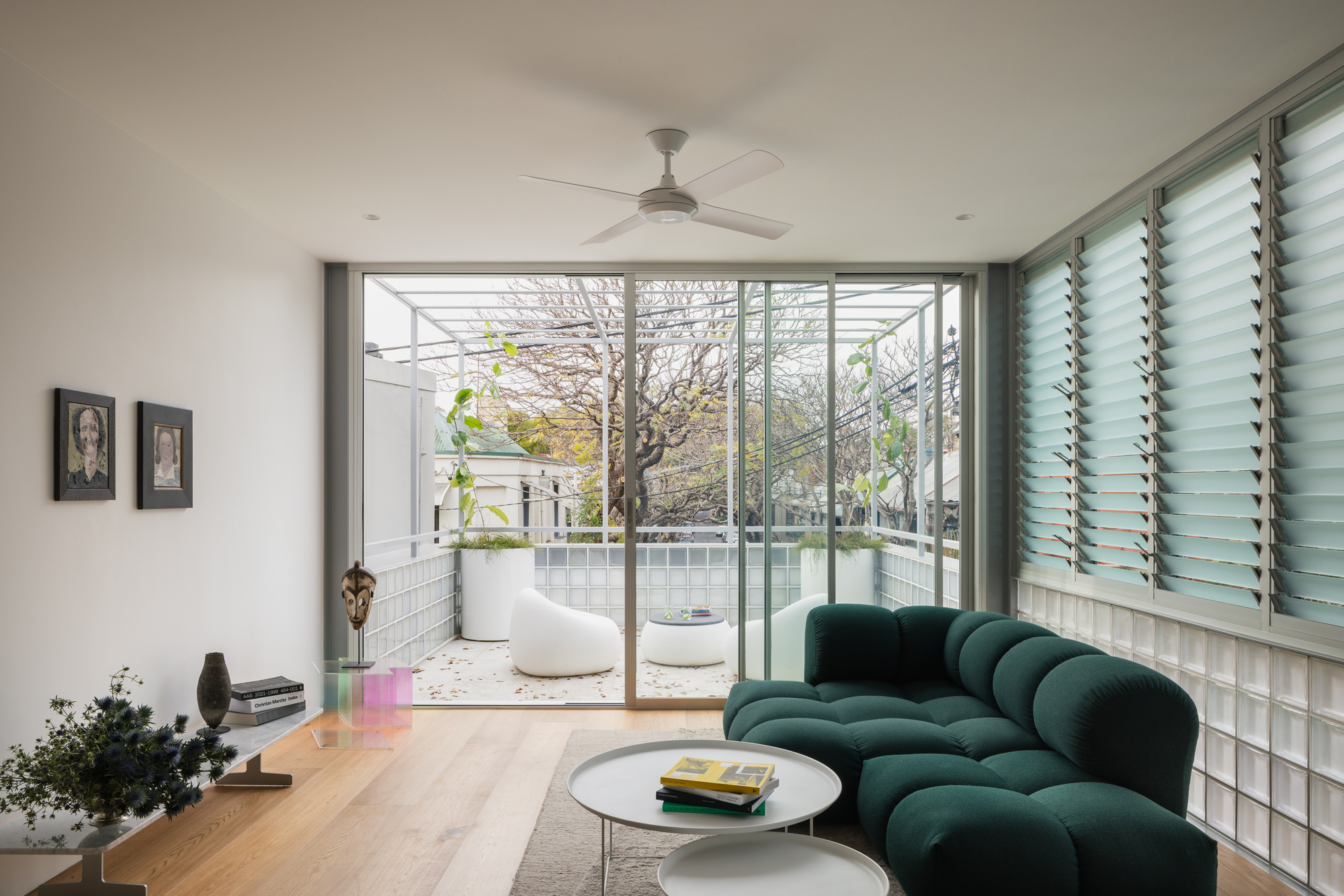 Living room with glass block wall and sliding doors opening to a terrazzo courtyard