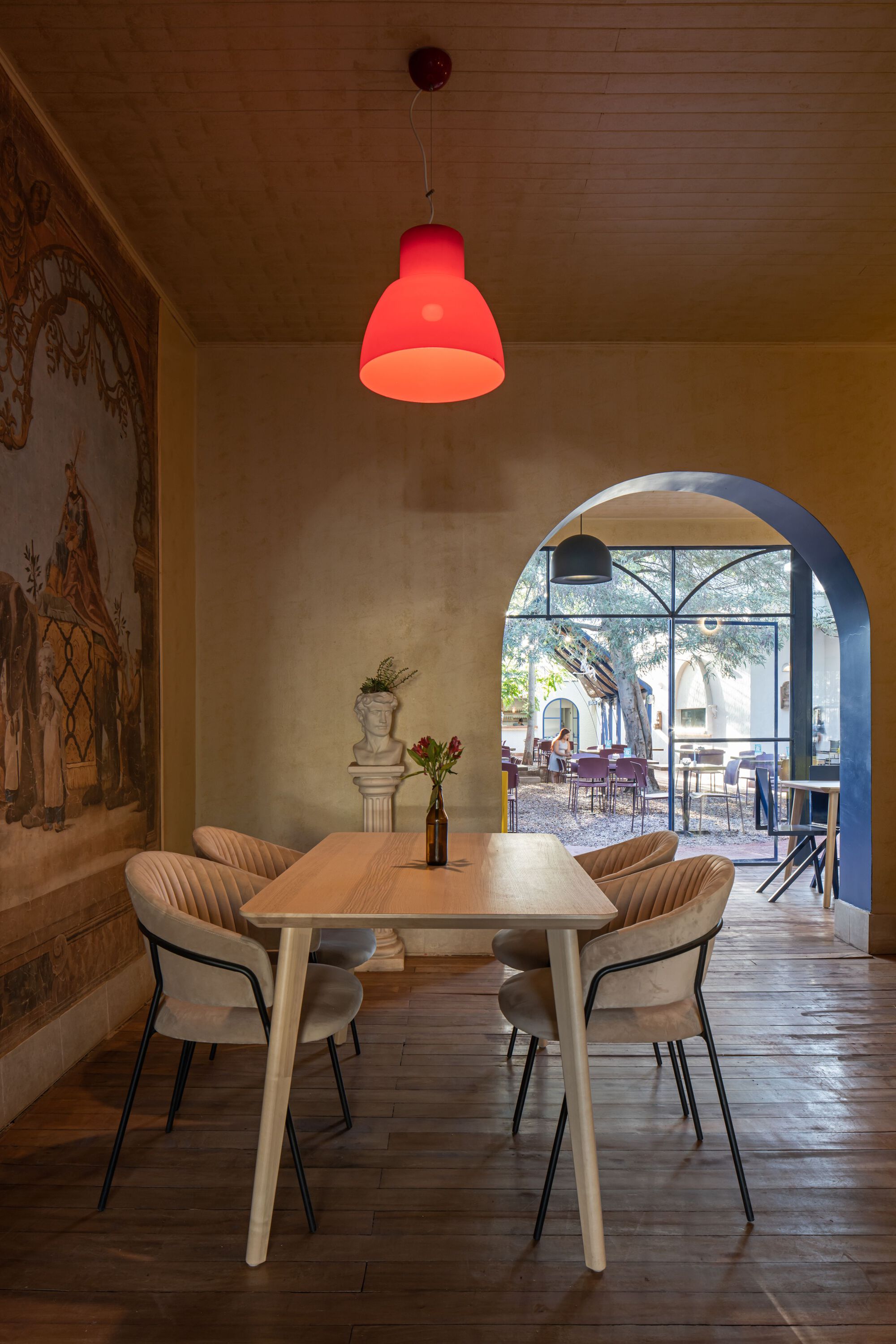 Dining room with arched doorway framing a view to the courtyard beyond