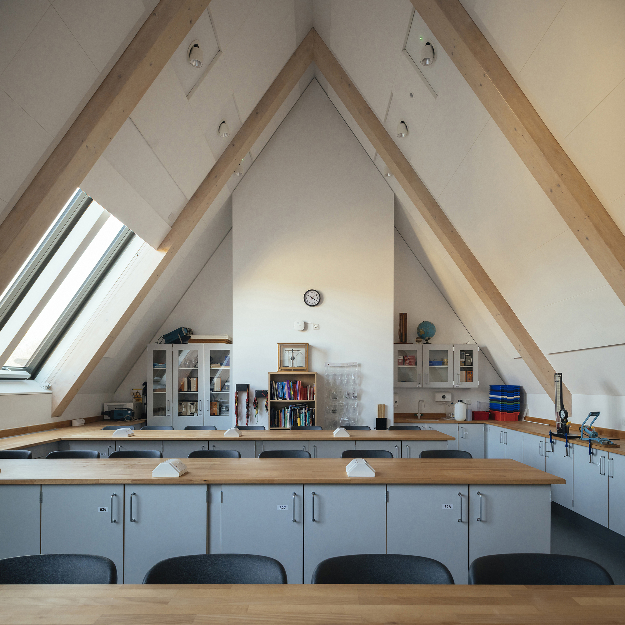 Laboratory benches beneath a vaulted ceiling with exposed timber rafters and a roof window