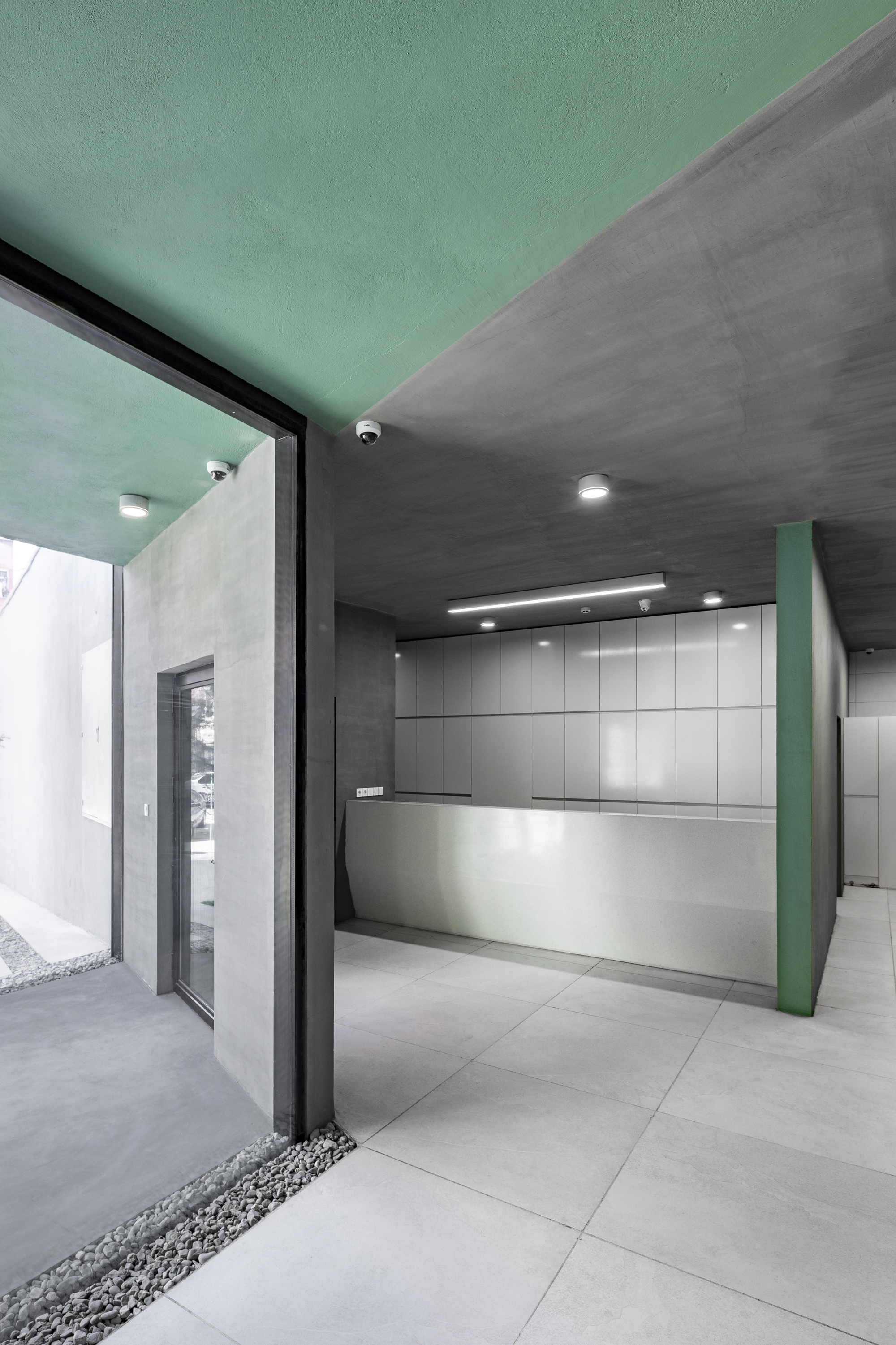 Kitchen with mint green ceiling, grey tile walls, and large floor-to-ceiling glass doors opening to courtyard