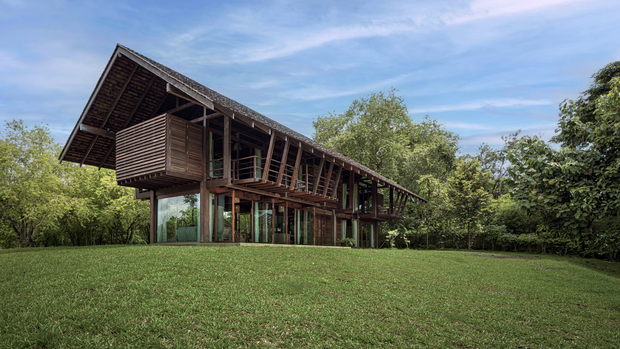 Side elevation showing the raised timber structure with exposed rafters and deep overhanging roof above a lawn
