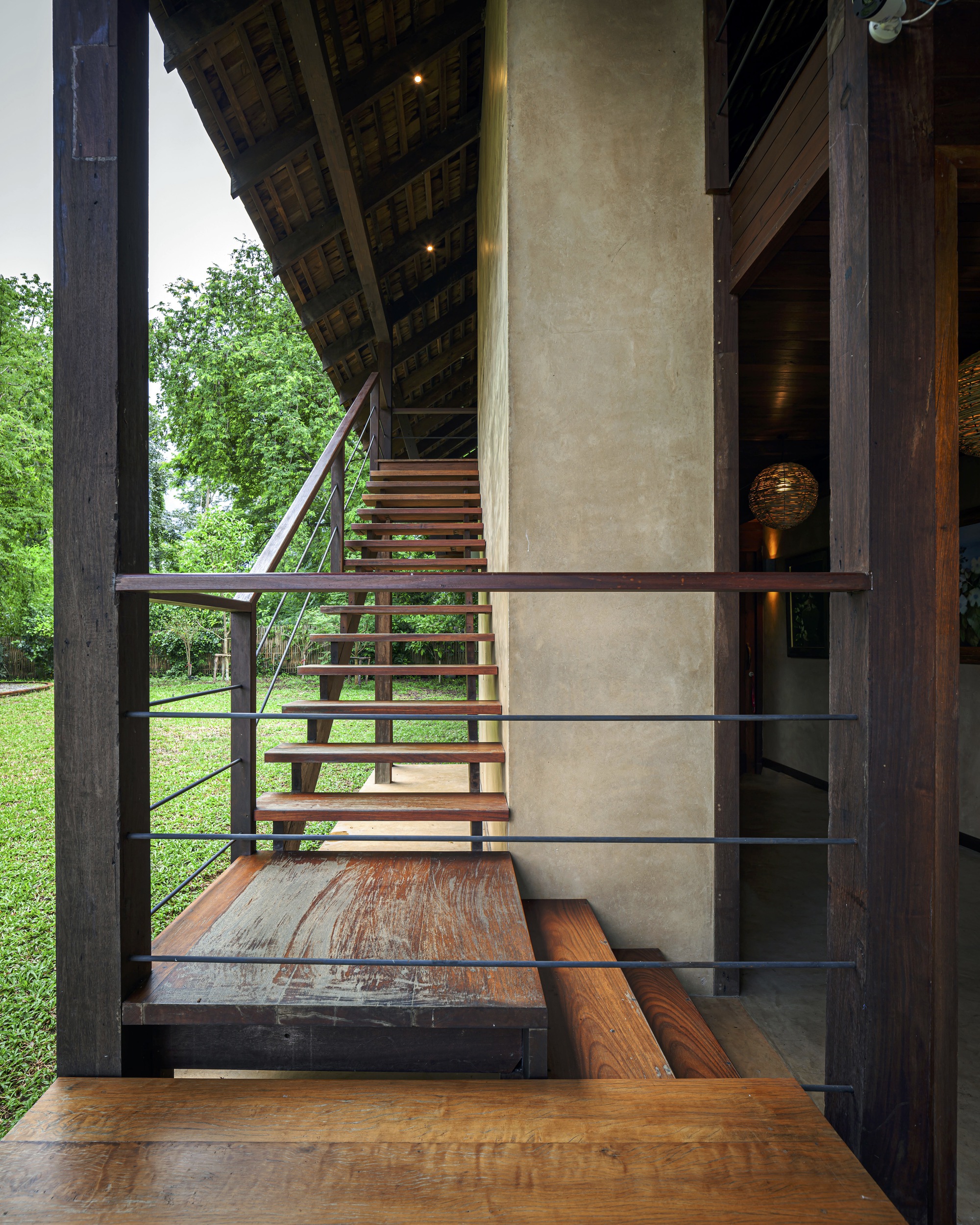 Interior view from timber stair landing showing polished plaster core wall and open tread staircase with steel railings