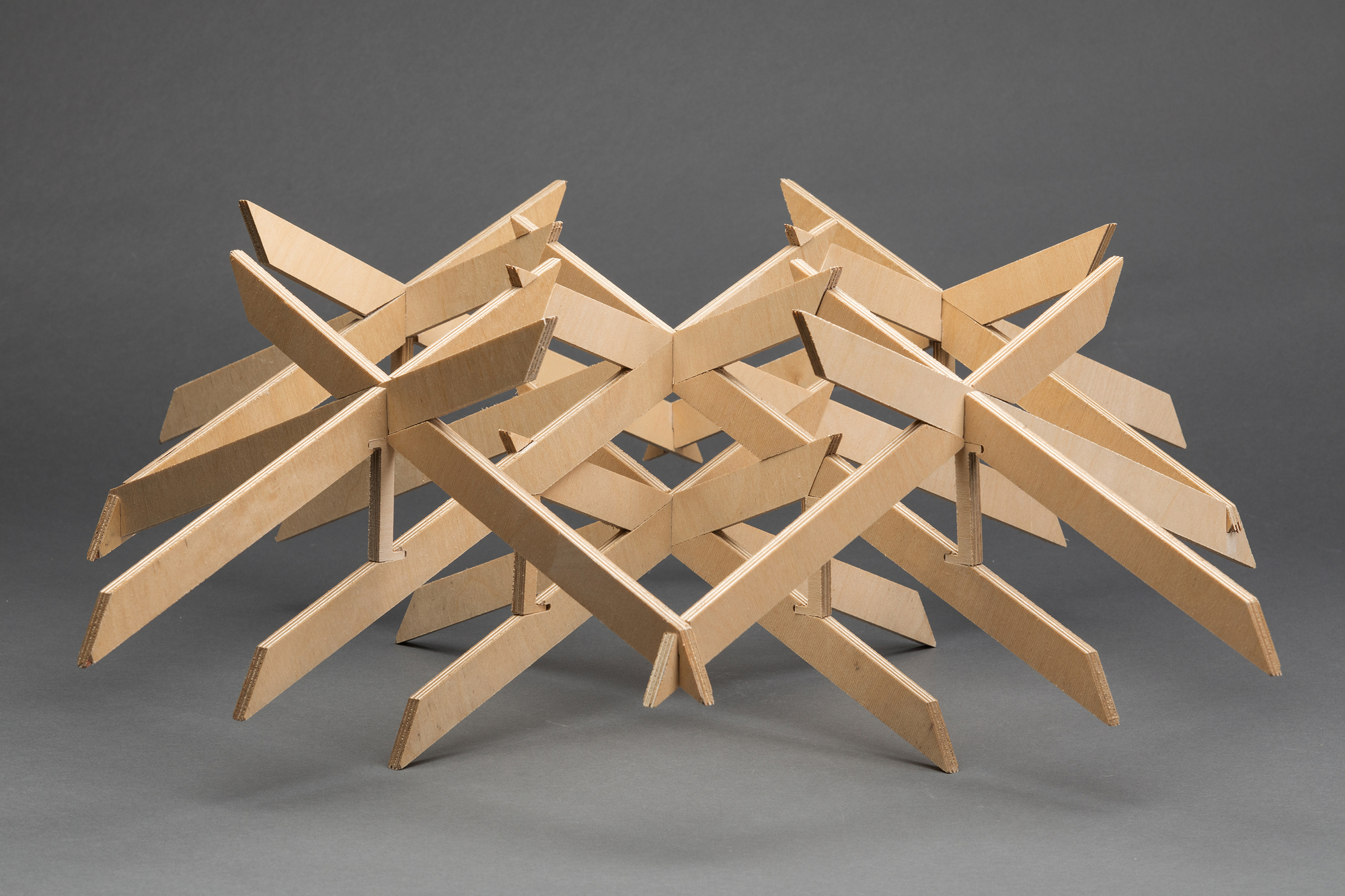 Plywood structural model with interlocking beams arranged in a radiating grid pattern