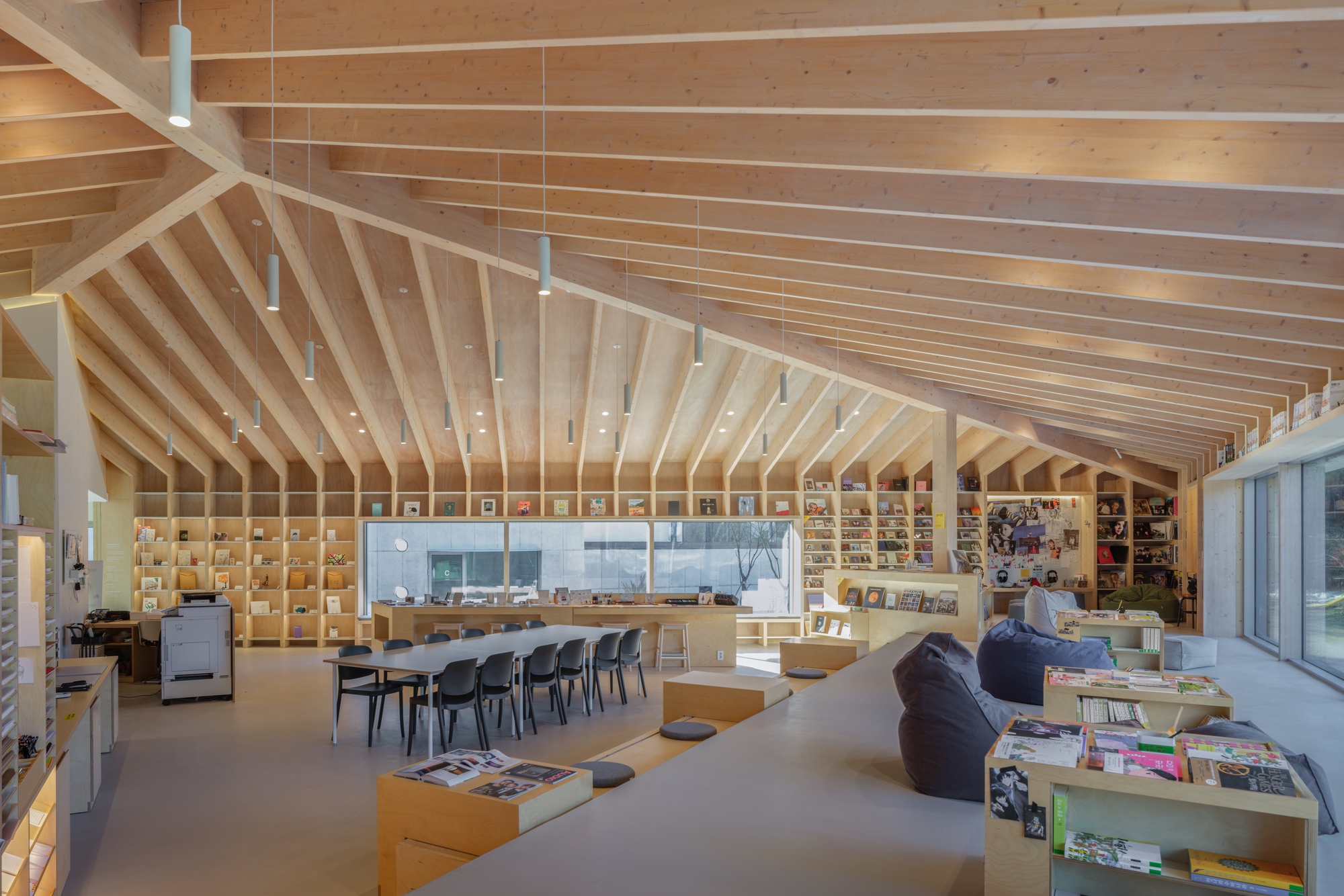 Interior library space with radiating timber ribs spanning the ceiling and bookshelves lining the perimeter walls