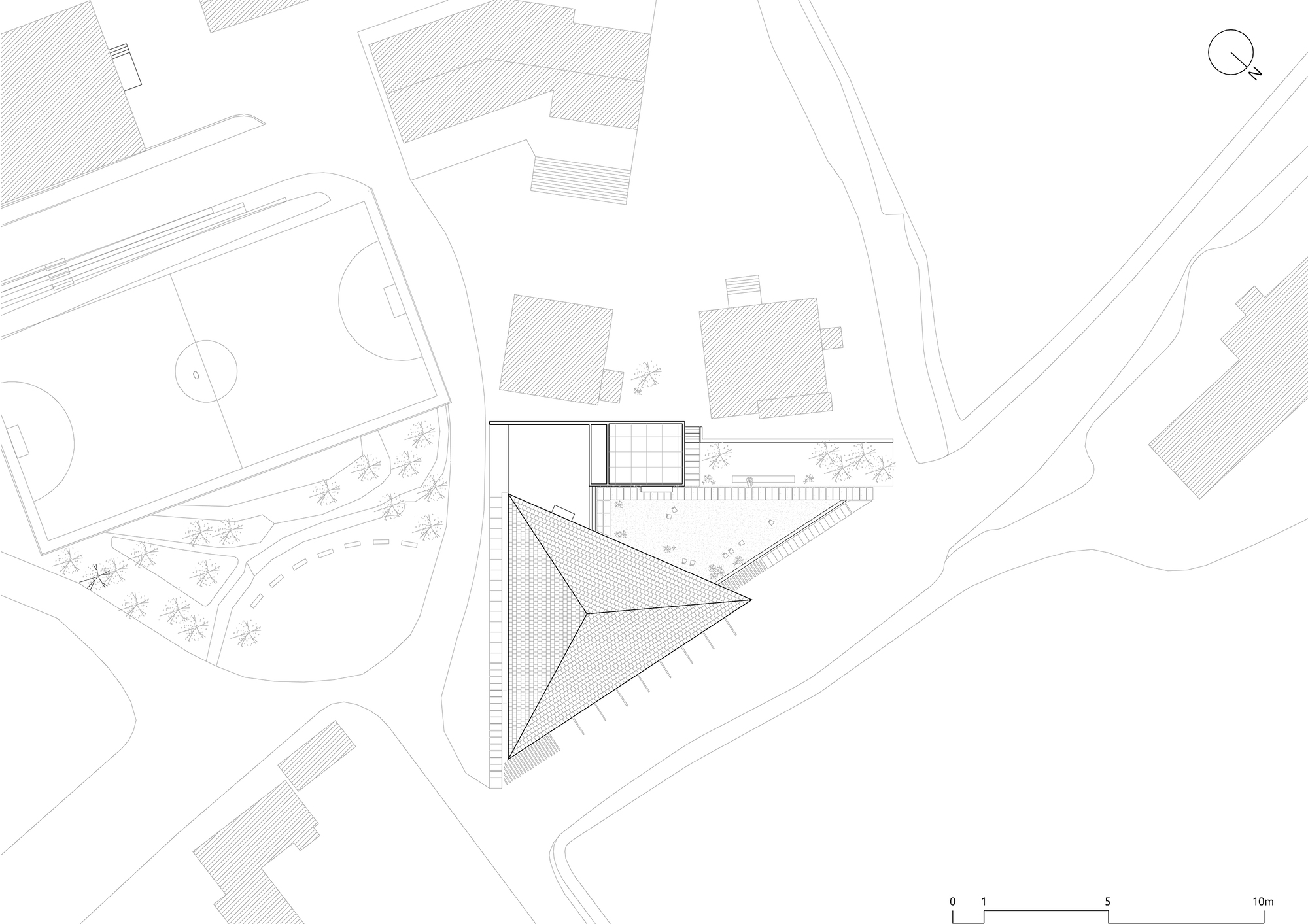 Site plan drawing showing a triangular building footprint with adjacent structures and landscaping