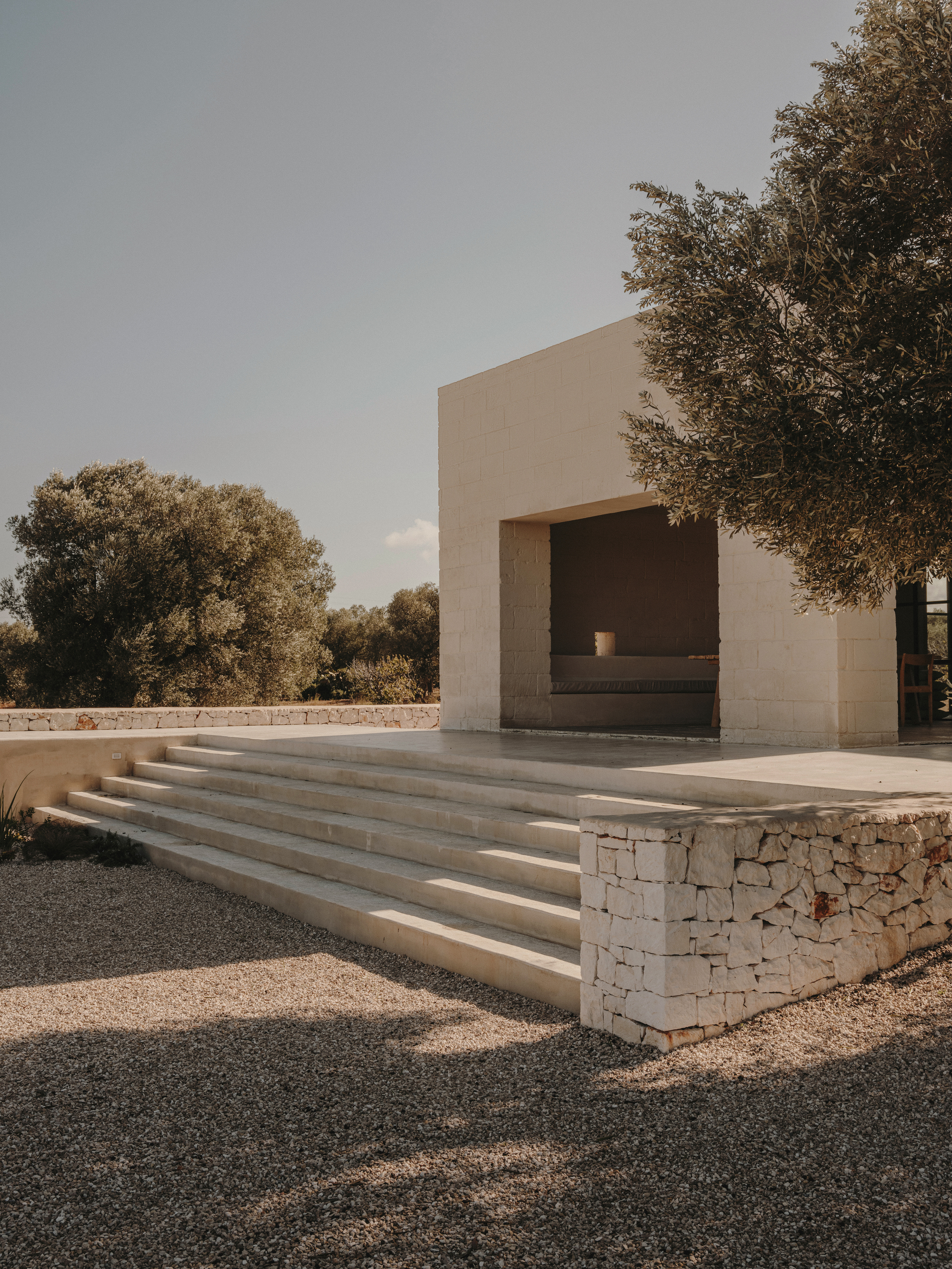 Wide stone steps with gabion retaining wall leading to a terrace pavilion