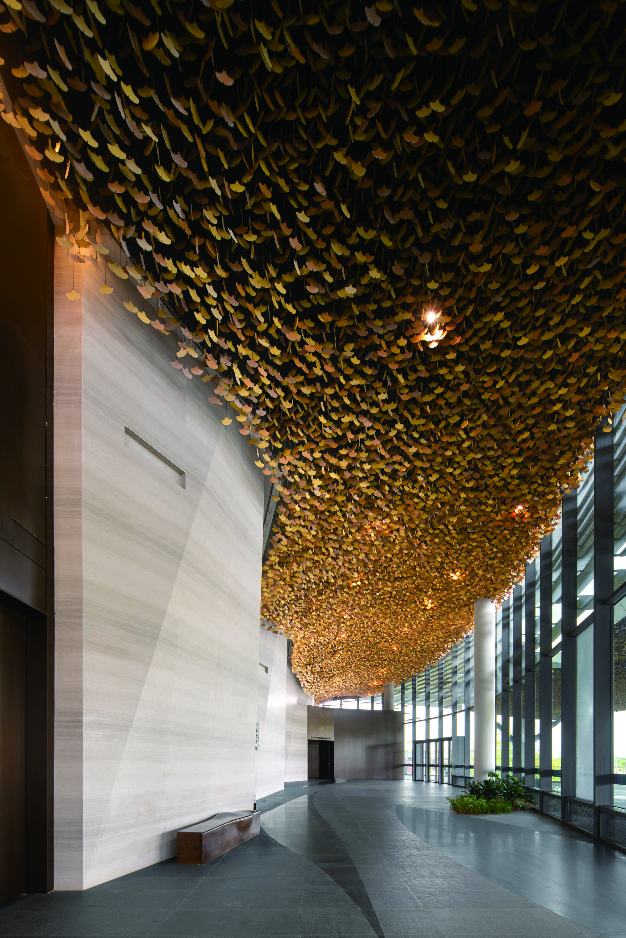 Entrance lobby with textured golden ceiling installation cascading above the polished stone floor