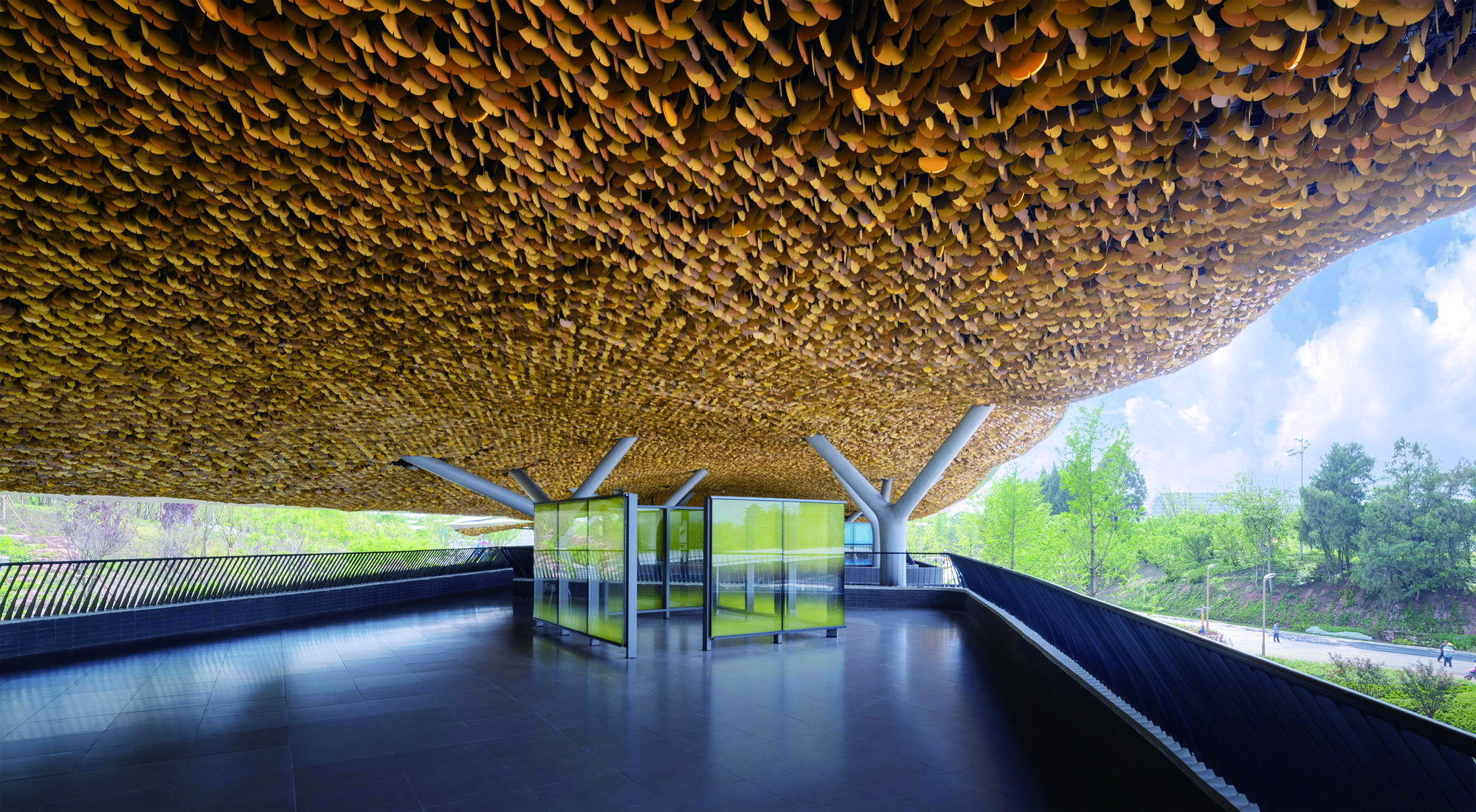 Interior view of the golden scalloped ceiling canopy supported by branching columns overlooking green fields
