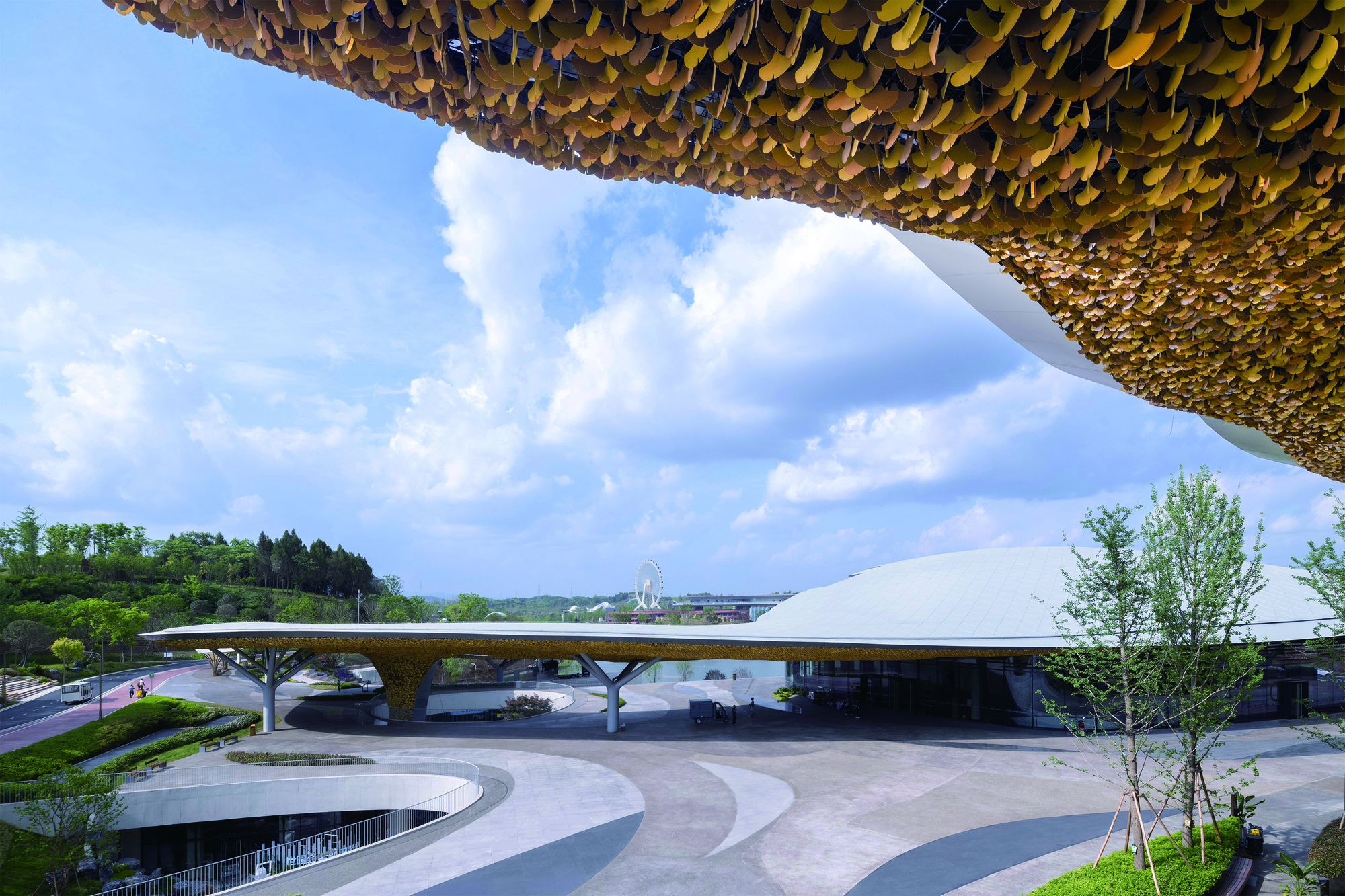 Exterior view of the golden scalloped canopy roof sheltering the white curved entrance pavilion below