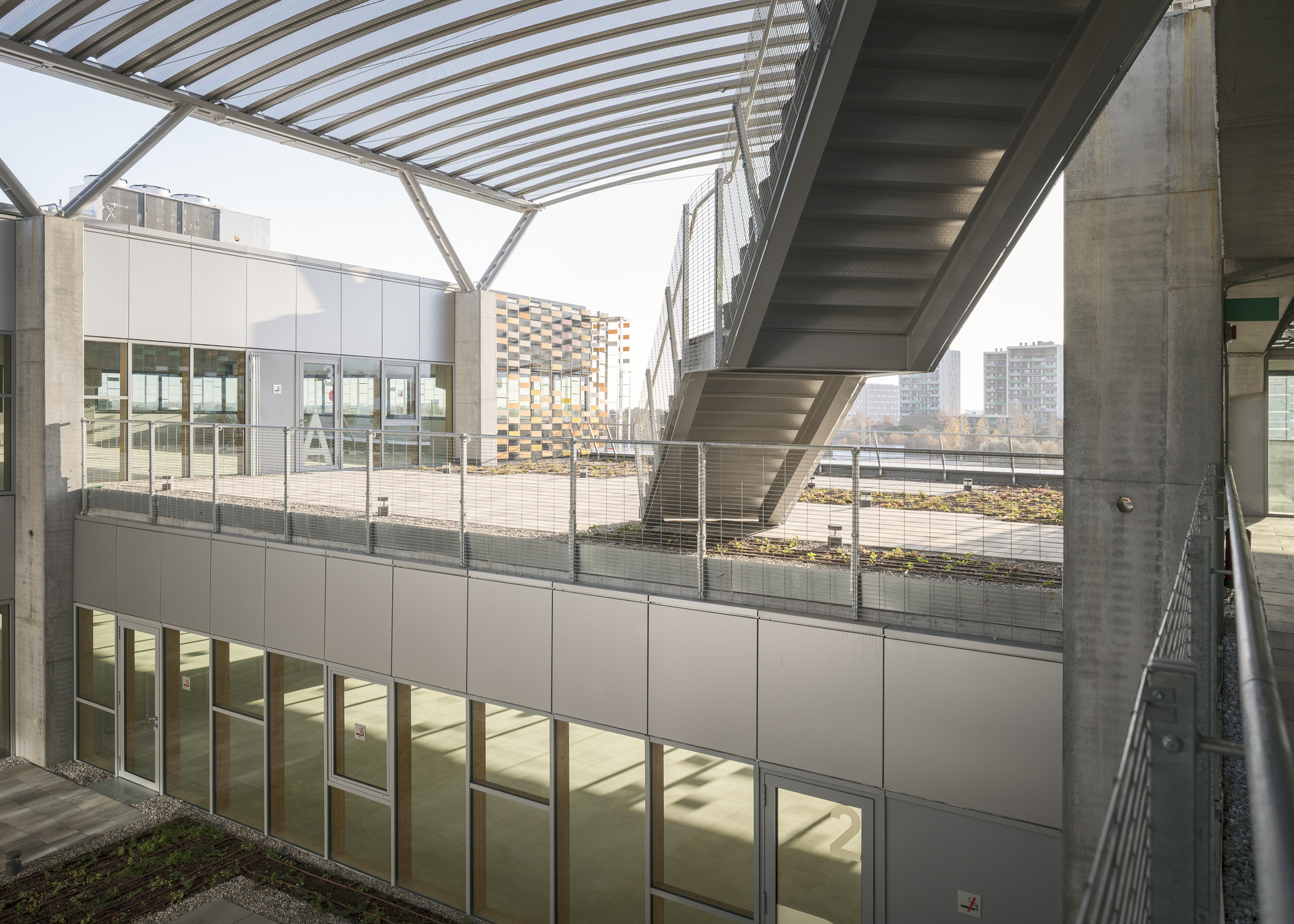 Exterior terrace with concrete staircase, metal cladding and patterned canopy structure above