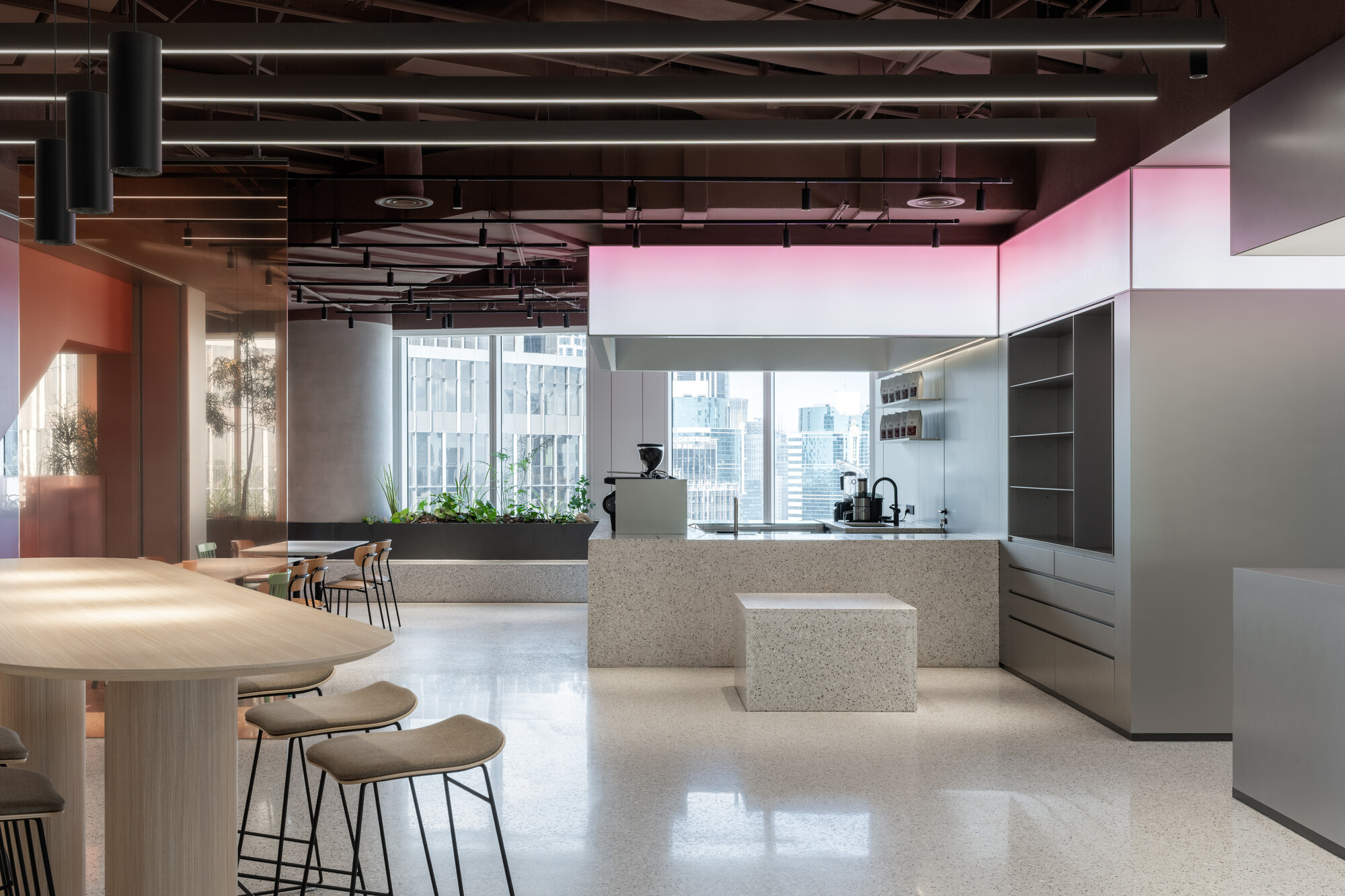 This architectural image showcases a modern office space with a focus on minimalist design and natural light. The interior features terrazzo flooring, a kitchen