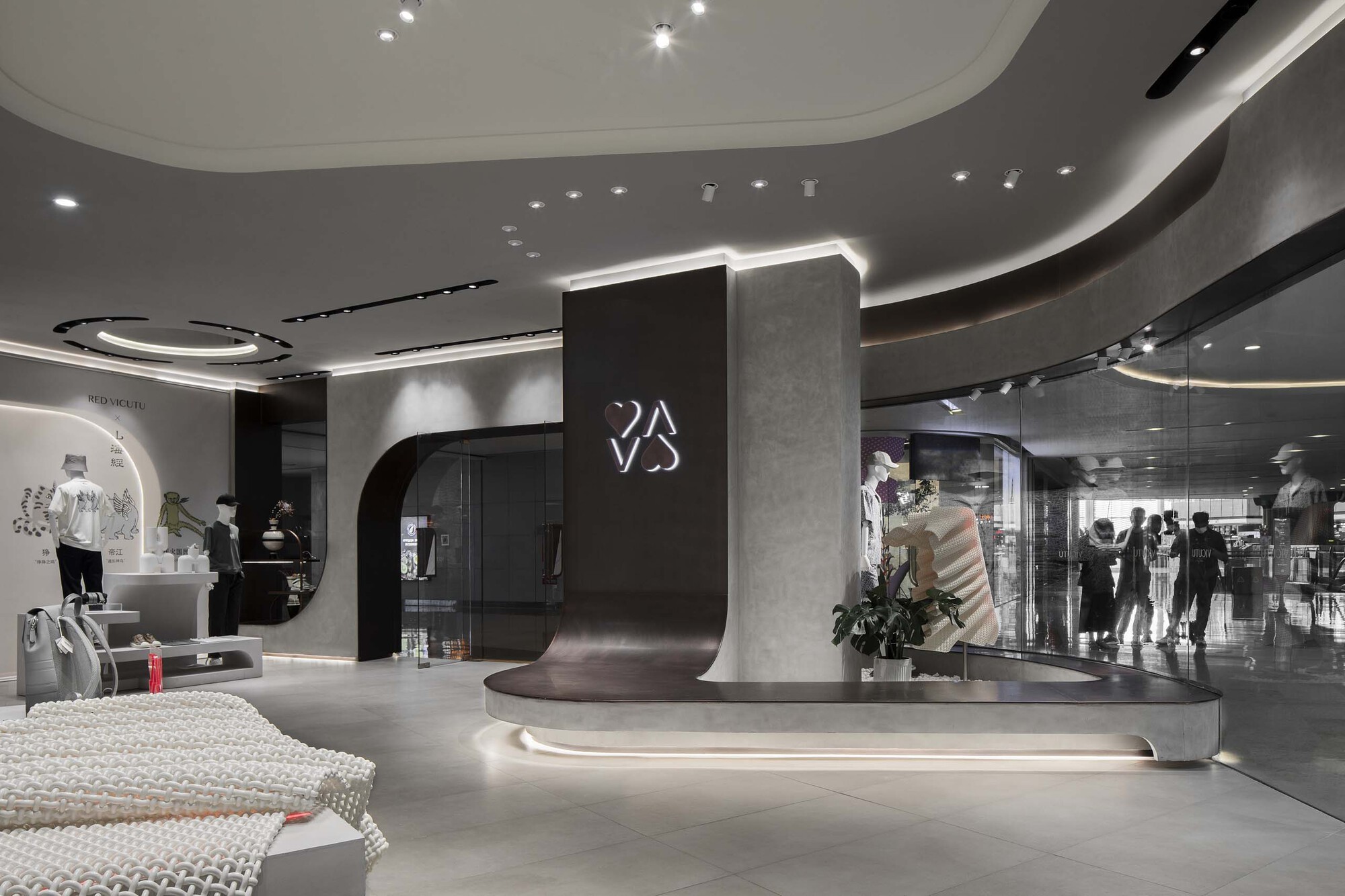 Central circulation space showing the curved reception desk with backlit signage and shoppers in the background