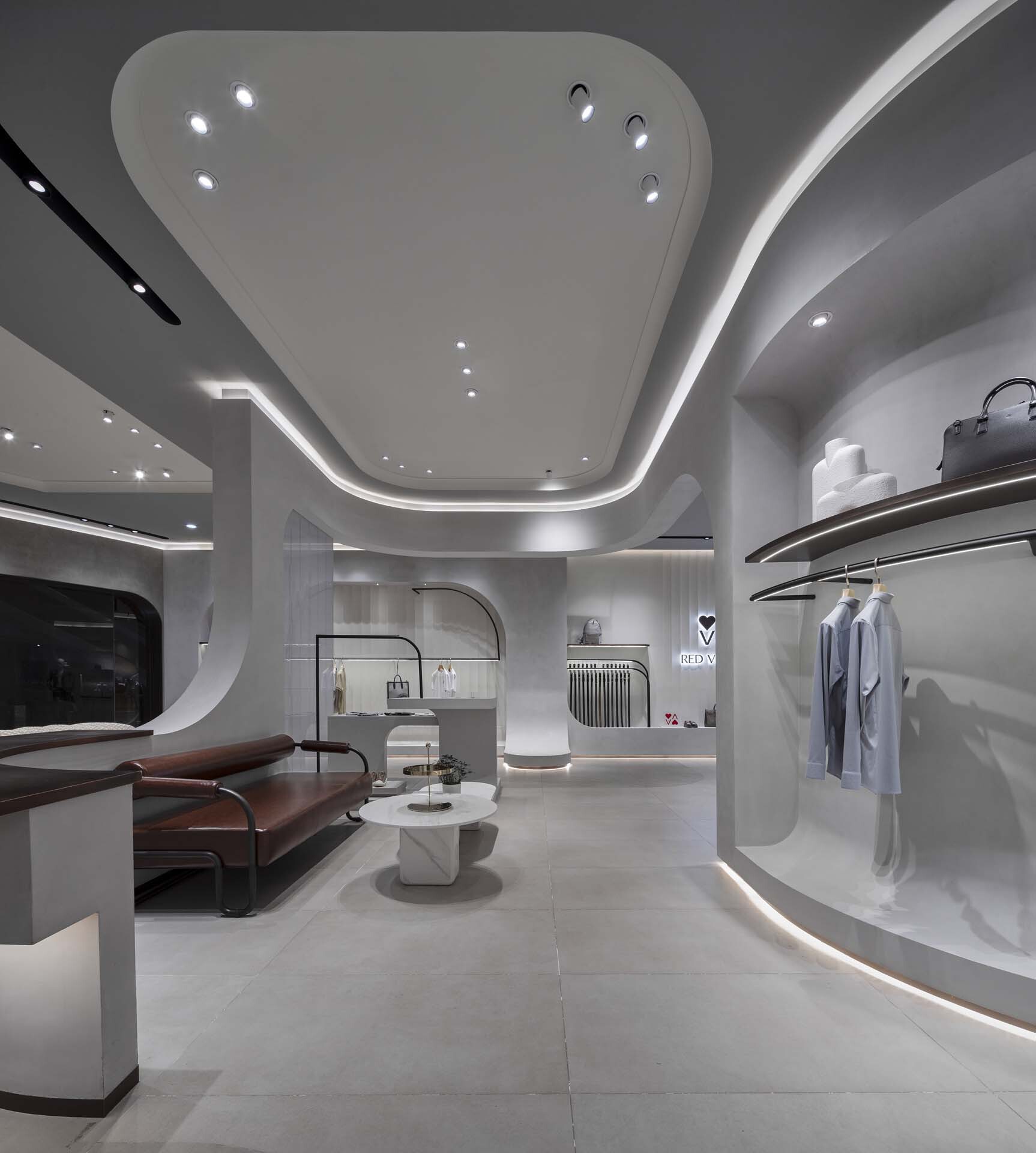 Seating area with curved ceiling soffit and illuminated display niches along perimeter wall