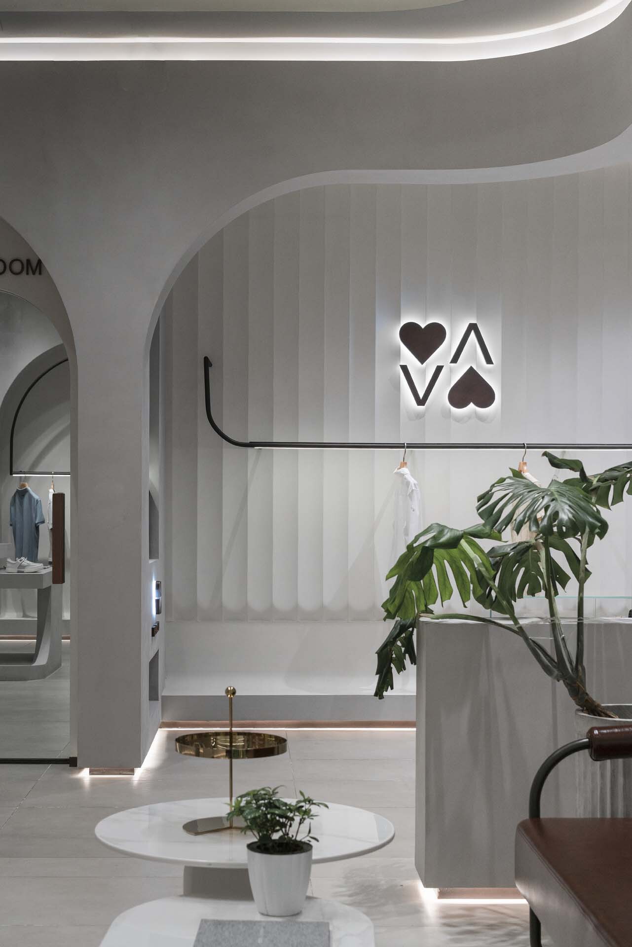 Vertical striped wall panels with backlit logo and arched openings framing merchandise displays